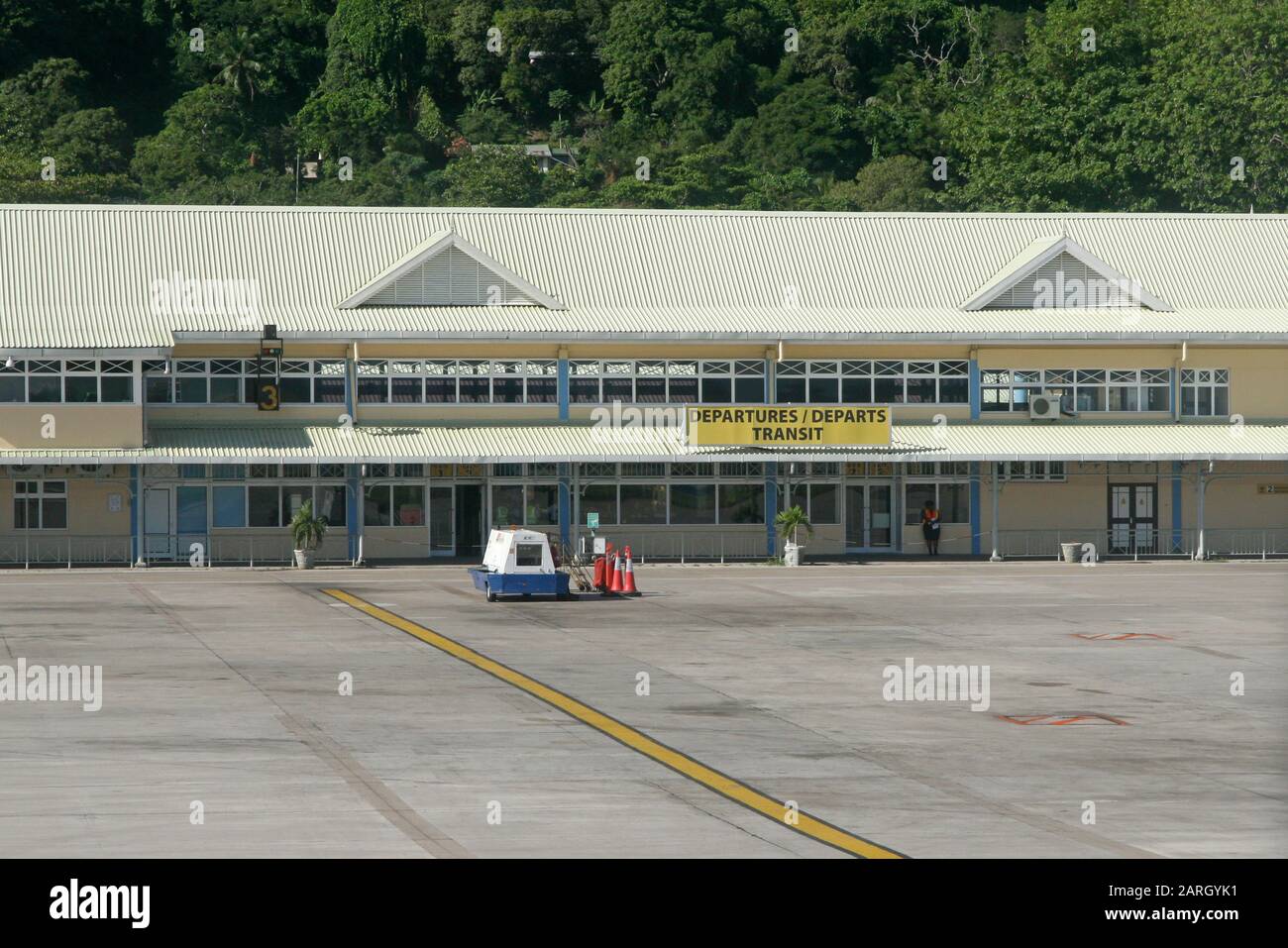 Rimorchio che trasporta coni di sicurezza vicino all'edificio di partenza, all'Aeroporto di Mahe, Seychelles. Foto Stock