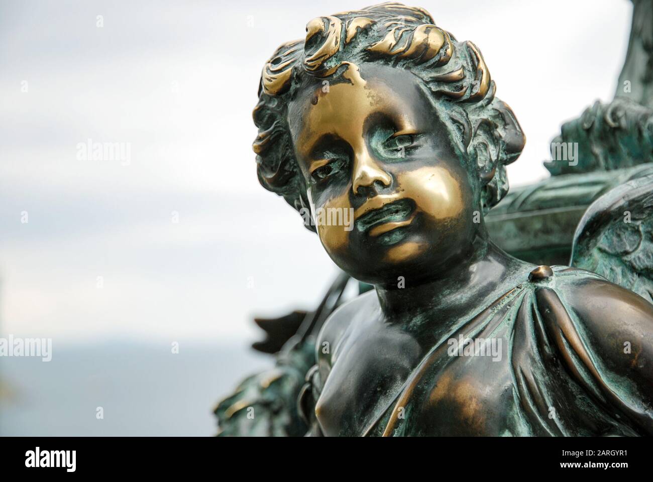 Vecchia statua in bronzo ossidato di un ragazzo con macchie lucidate sul suo viso come simbolo di malattia della pelle, patologia o condizione come vitiligo o psoriasi Foto Stock