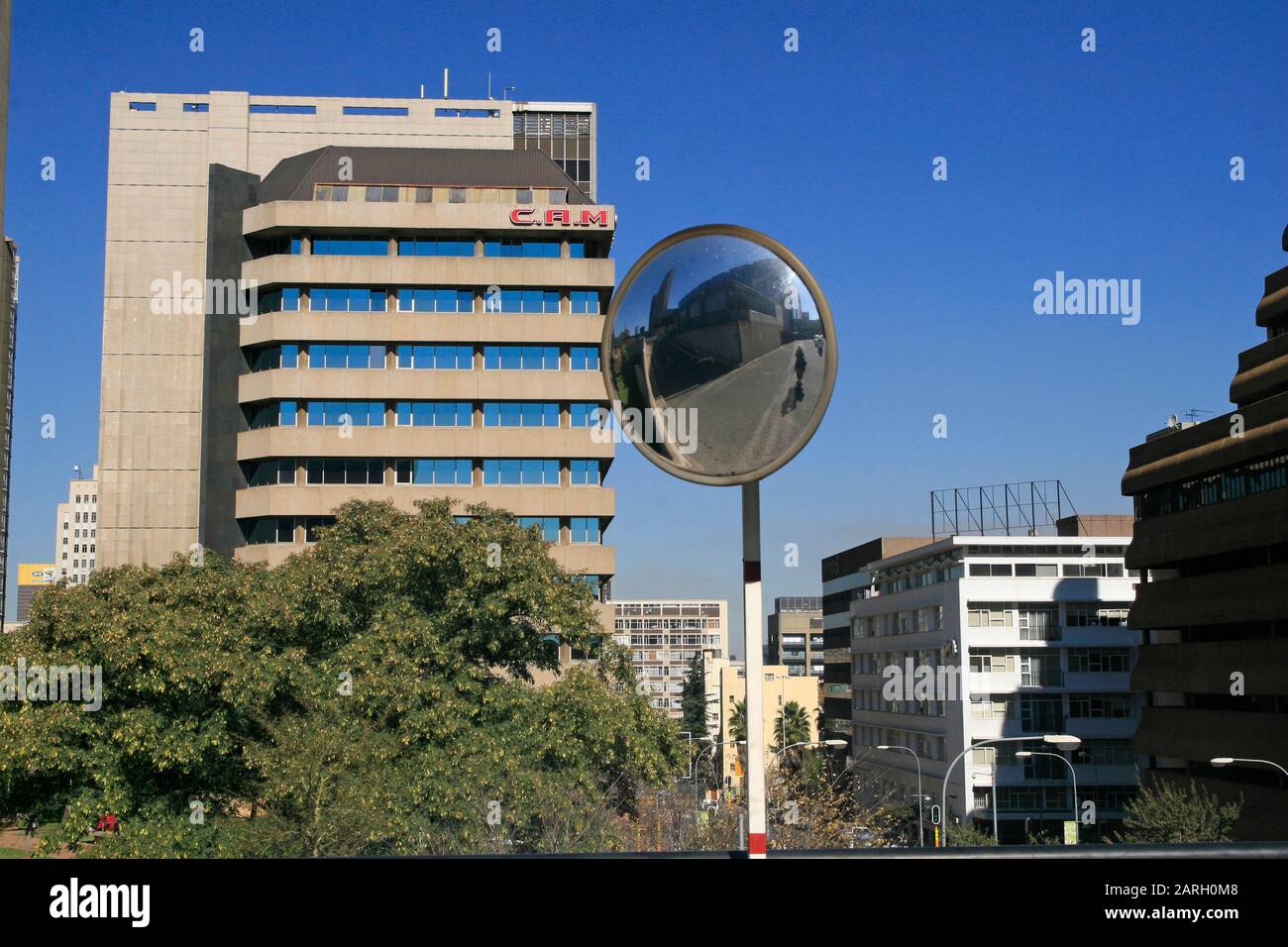 Specchio per il traffico con edificio e albero C.A.M., Braamfontein, Johannesburg, Gauteng, Sud Africa. Foto Stock