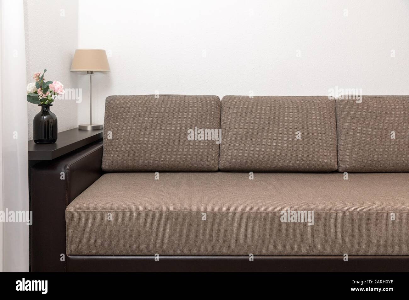 interno soggiorno con divano in tessuto marrone, mensola a muro e decorazioni Foto Stock