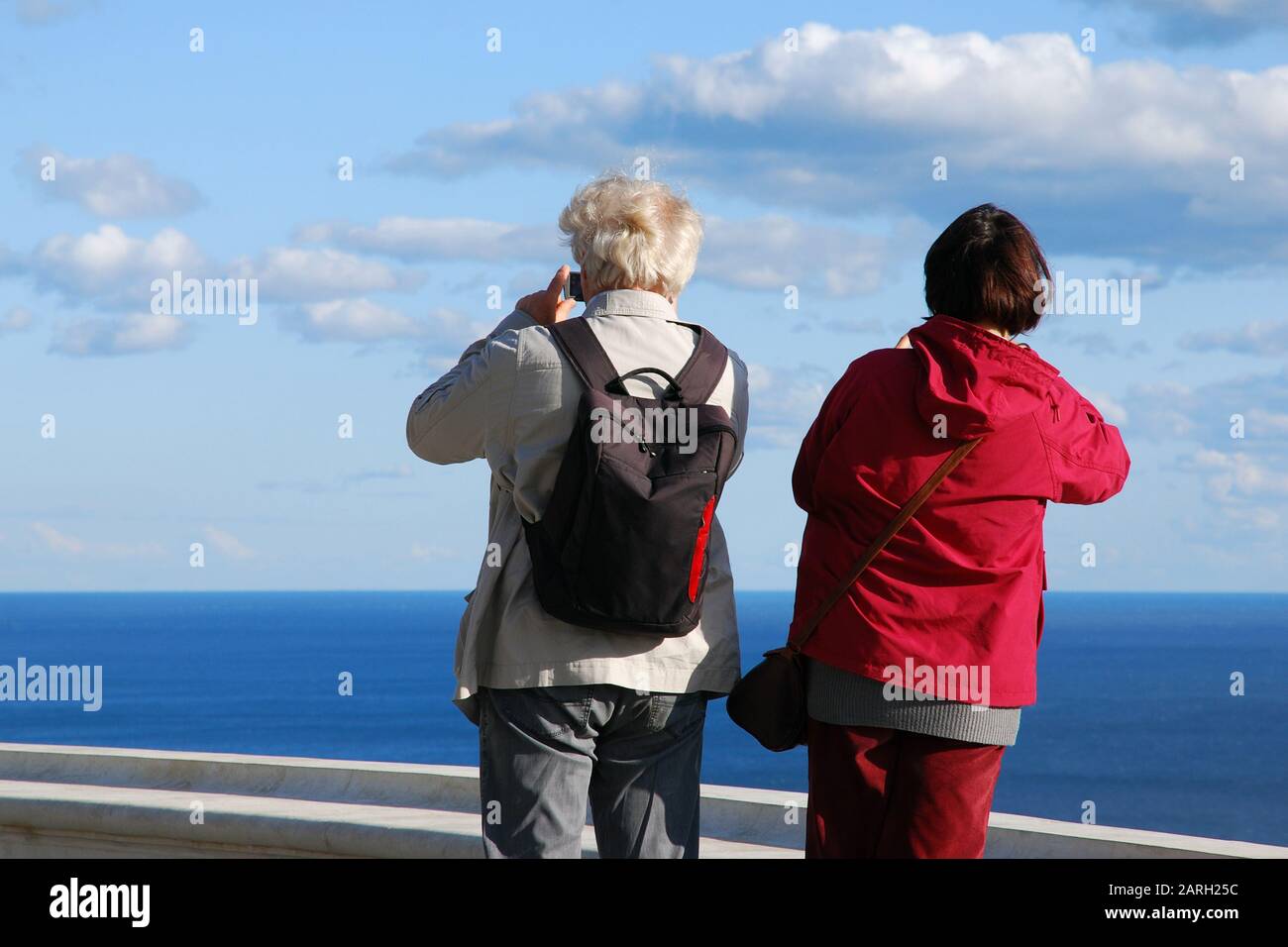 Coppie senior che viaggiano insieme, scattando le foto di bella vista del mare con i loro telefoni cellulari Foto Stock