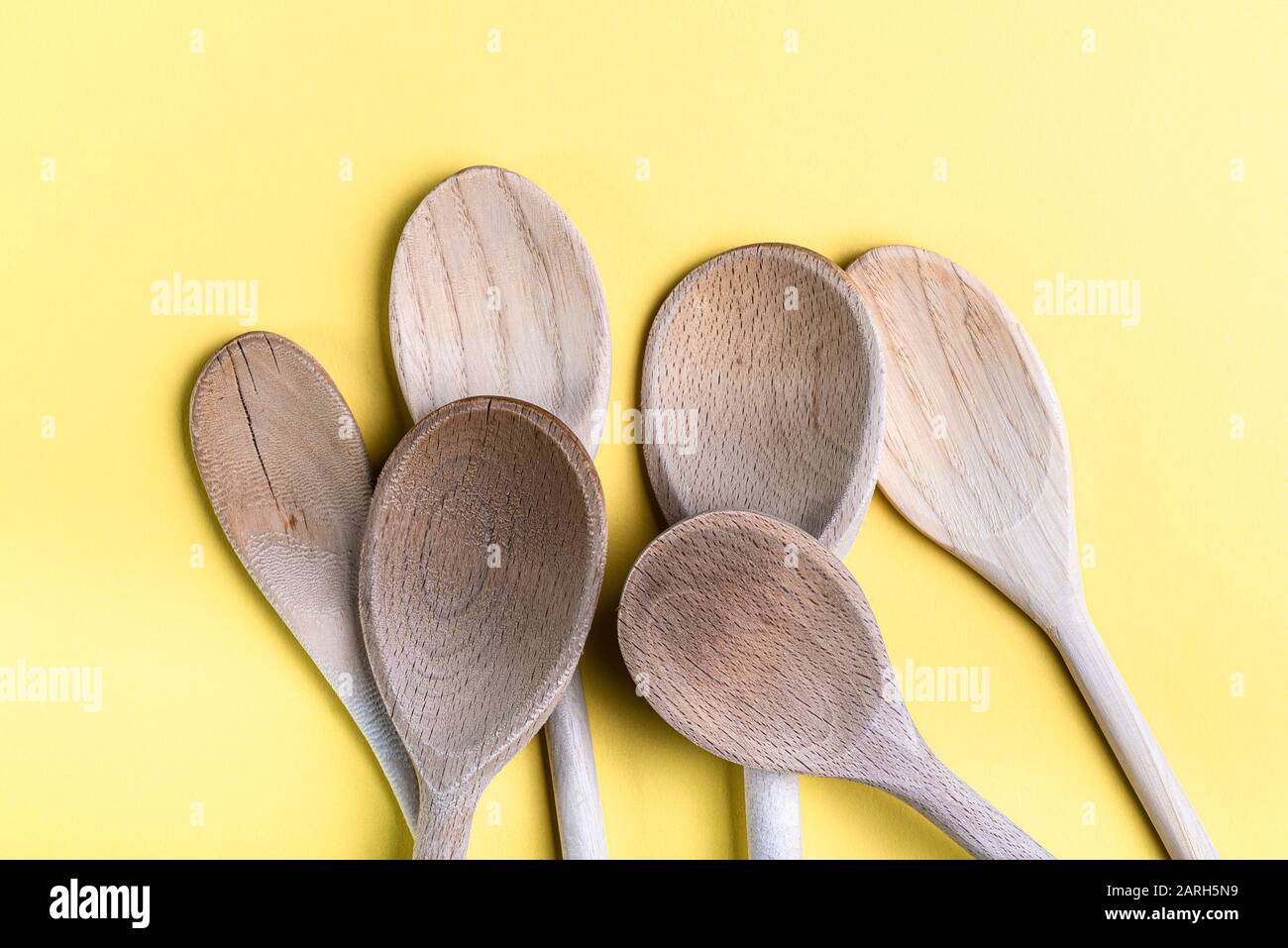 Gruppo di vecchi cucchiai di legno isolato su uno sfondo crema pallido. Foto Stock