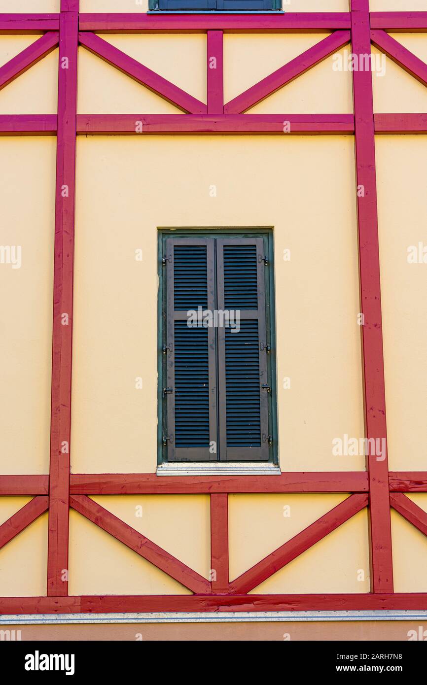 Facciata in legno incorniciato di un vecchio edificio con finestre in legno. Foto Stock