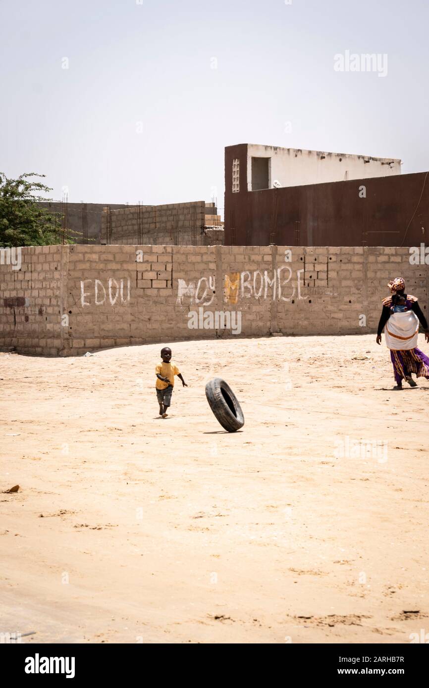 Un ragazzo senegalese sta giocando con un pneumatico, vicino a Saint-Louis, Senegal nord. Foto Stock