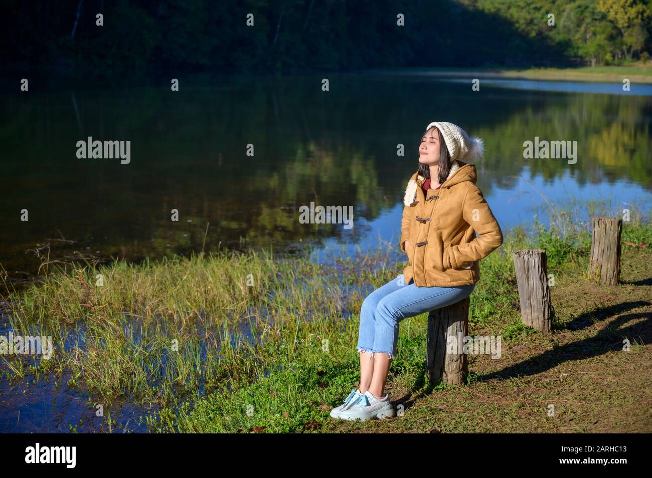 Donna rilassante viso occhi chiusi seduta dal fiume. Foto Stock