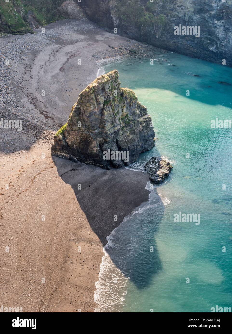 Guardando verso il basso la spiaggia e una piccola isola formata da erosione costiera dal sentiero ciclabile a piedi vicino Portreath, Cornovaglia. Foto Stock