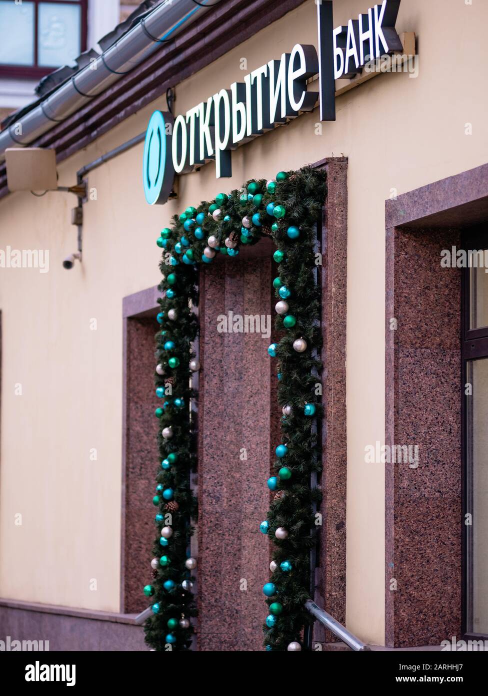 Mosca, Russia - 17 gennaio 2020: Otkritie Bank firma sopra l'ingresso. Garland di Natale di giocattoli di Natale e rami di abete intorno Foto Stock