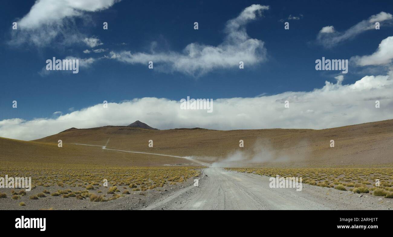 Safari auto si muove velocemente nella polvere, attraversando le ande boliviane Foto Stock