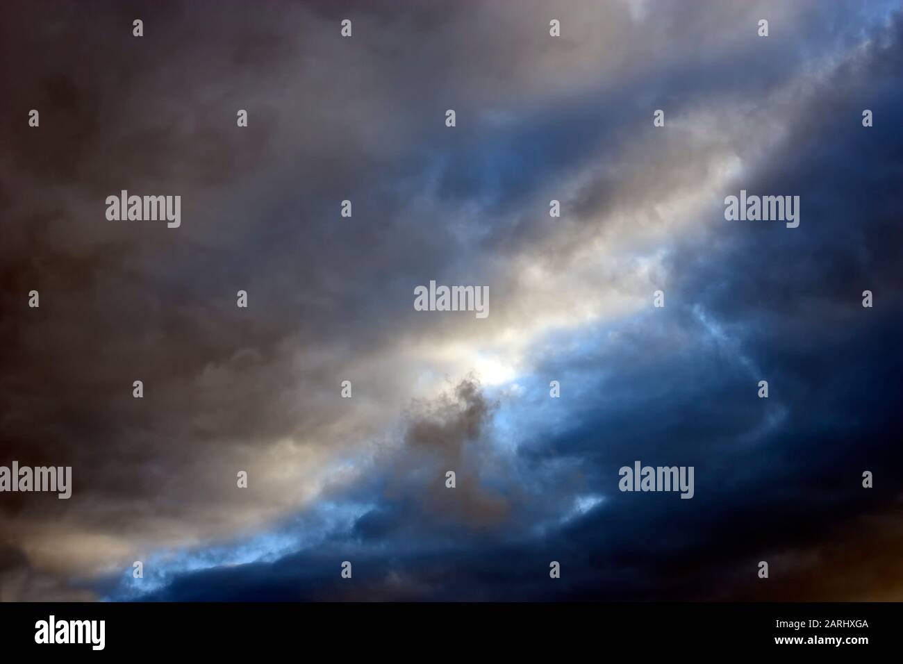 Le belle nuvole di tempesta di sera si stanno rompendo per mostrare un cielo azzurro chiaro sopra Foto Stock