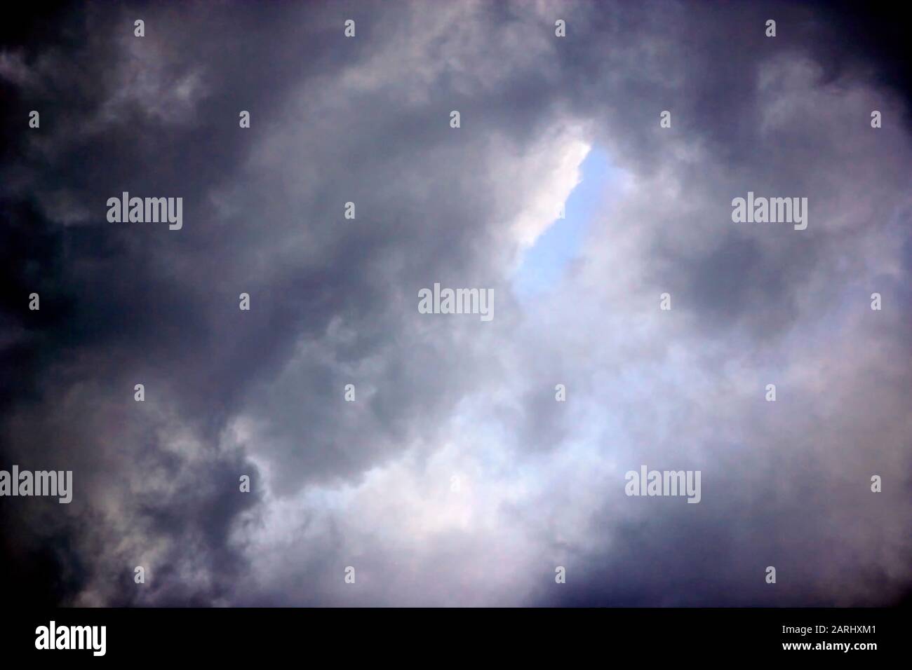 Storm Clouds Breaking up, mostrando un cielo blu pieno di speranza sopra catch up Foto Stock