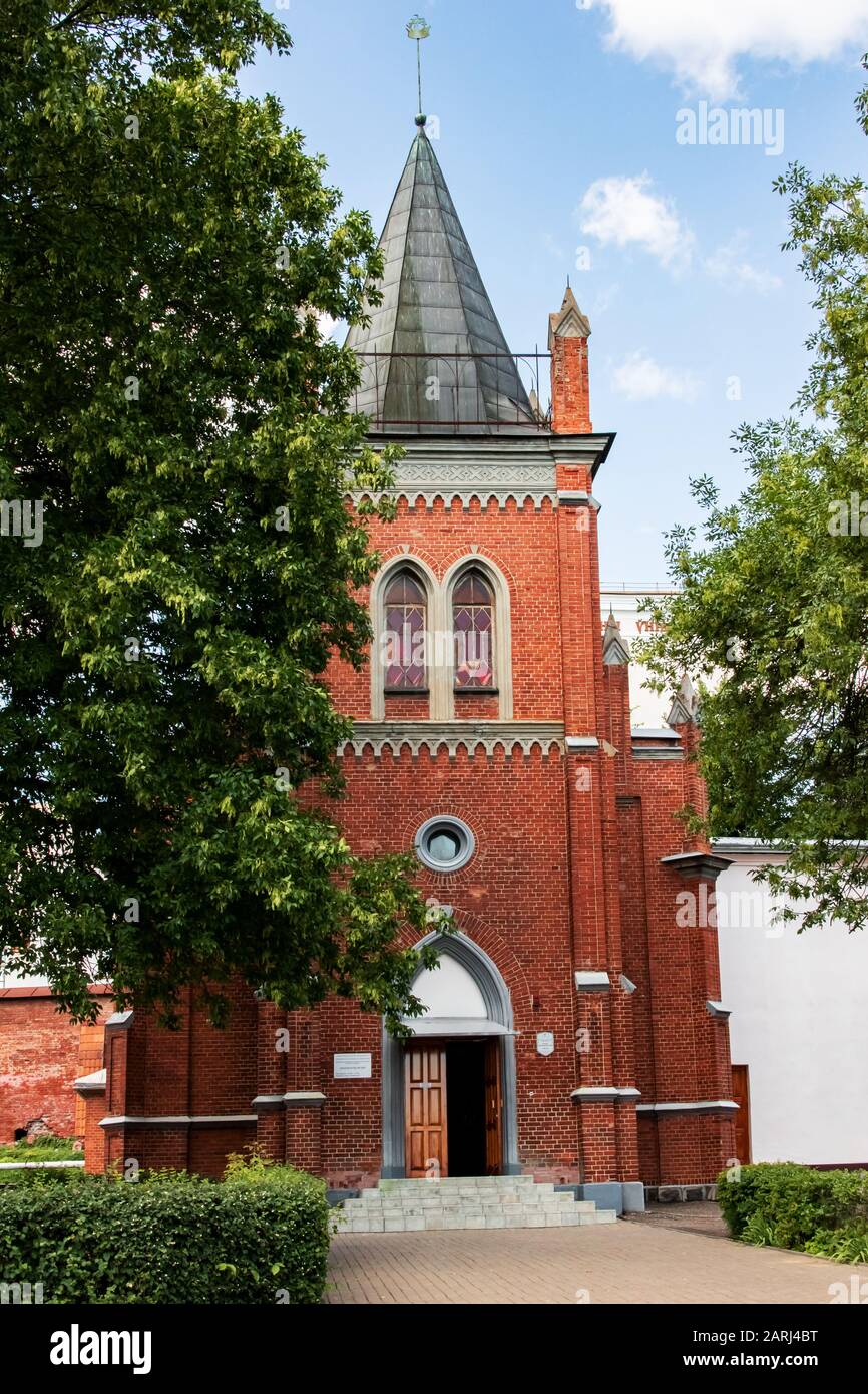 Vecchia chiesa di mattoni rossi tra gli alberi verdi a Polotsk in estate Foto Stock