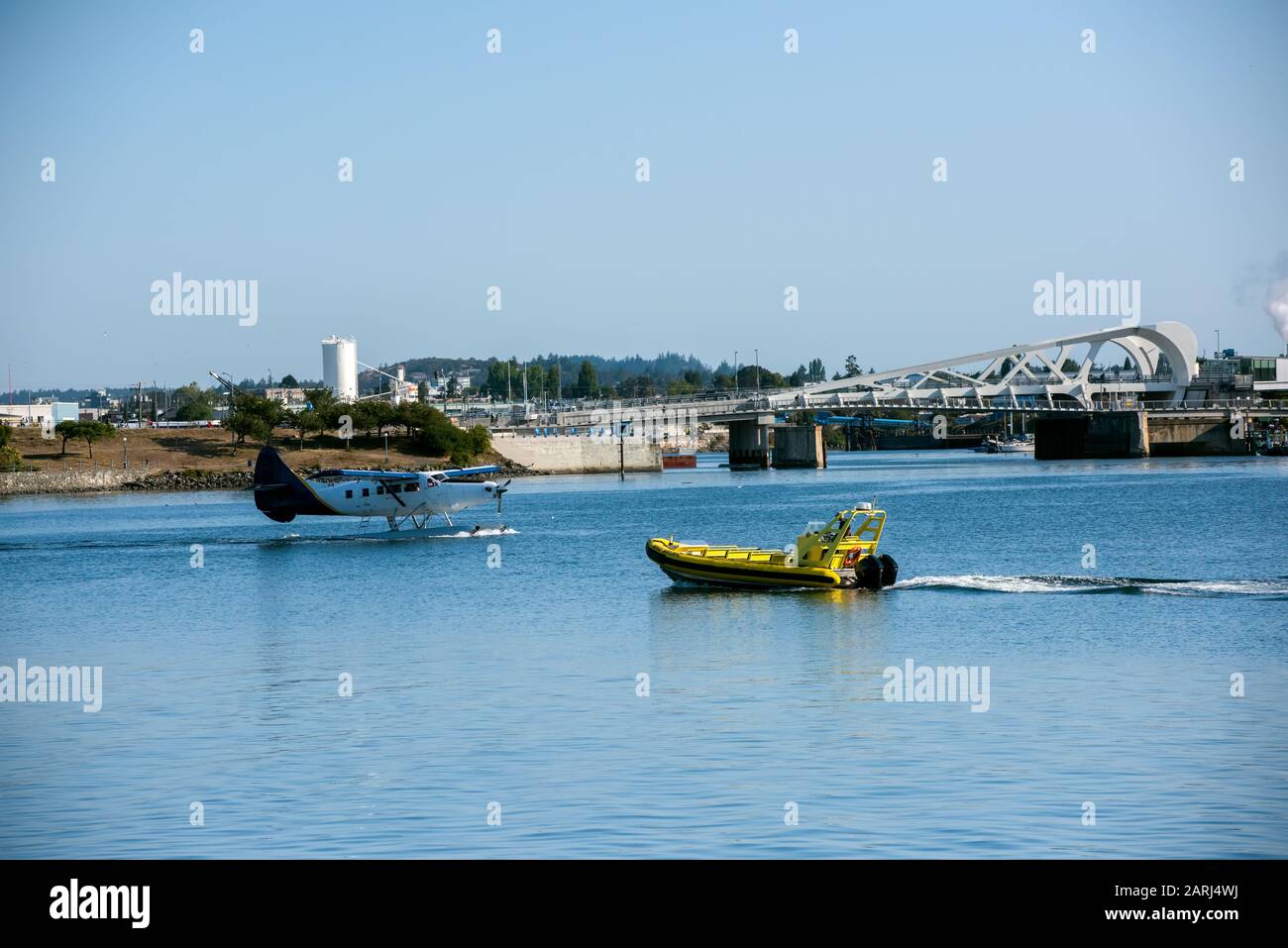 Un aereo galleggiante e una barca per l'avvistamento delle balene passano nel porto di Victoria (Canada). Foto Stock