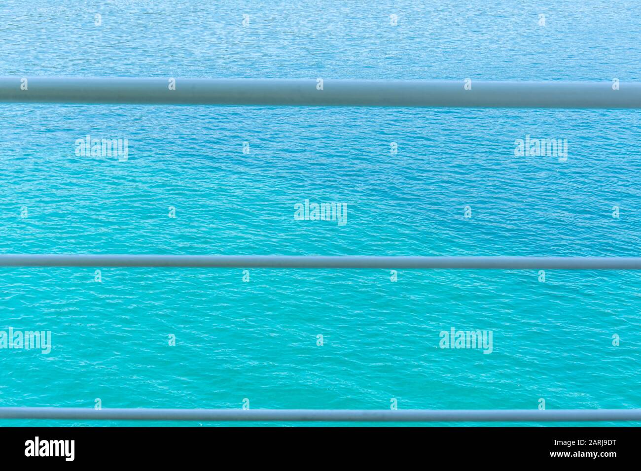 Mare per sfondo in un bel colore di acqua Menthe. Con tre linee bianche davanti ad esso. Bella e tranquilla foto. Foto Stock