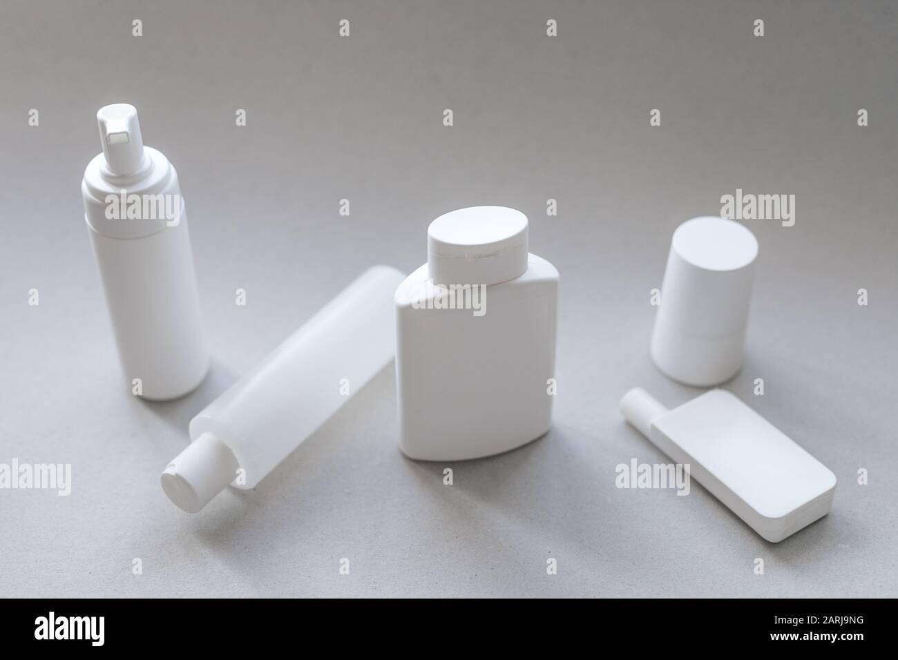 Una raccolta di contenitori cosmetici in plastica bianca per la cura del corpo e del viso con spazio bianco Foto Stock