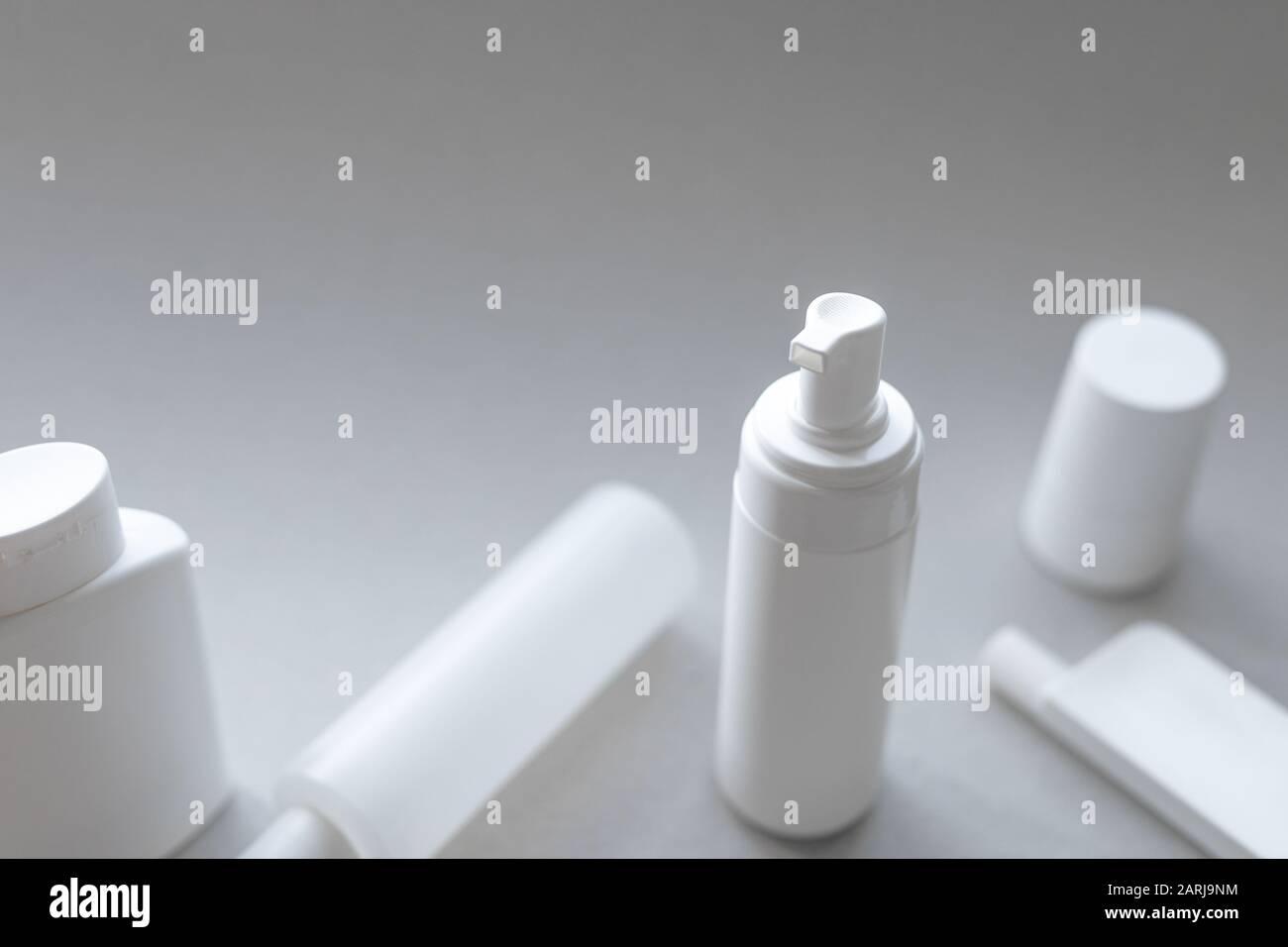 Una raccolta di contenitori cosmetici in plastica bianca per la cura del corpo e del viso con spazio bianco Foto Stock