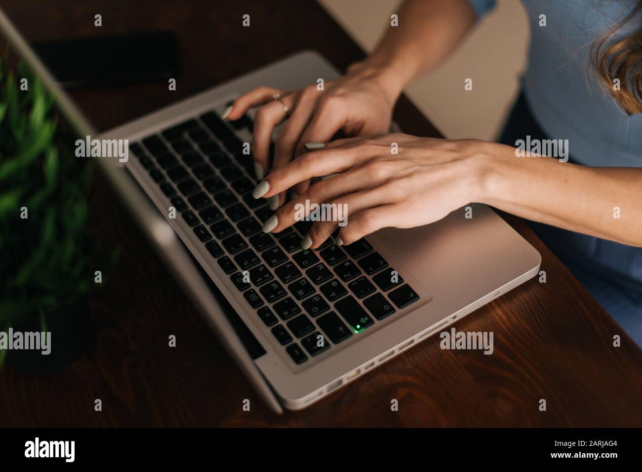 Il primo piano delle mani delle donne sta digitando sulla tastiera del computer portatile, una inserisce la password Foto Stock