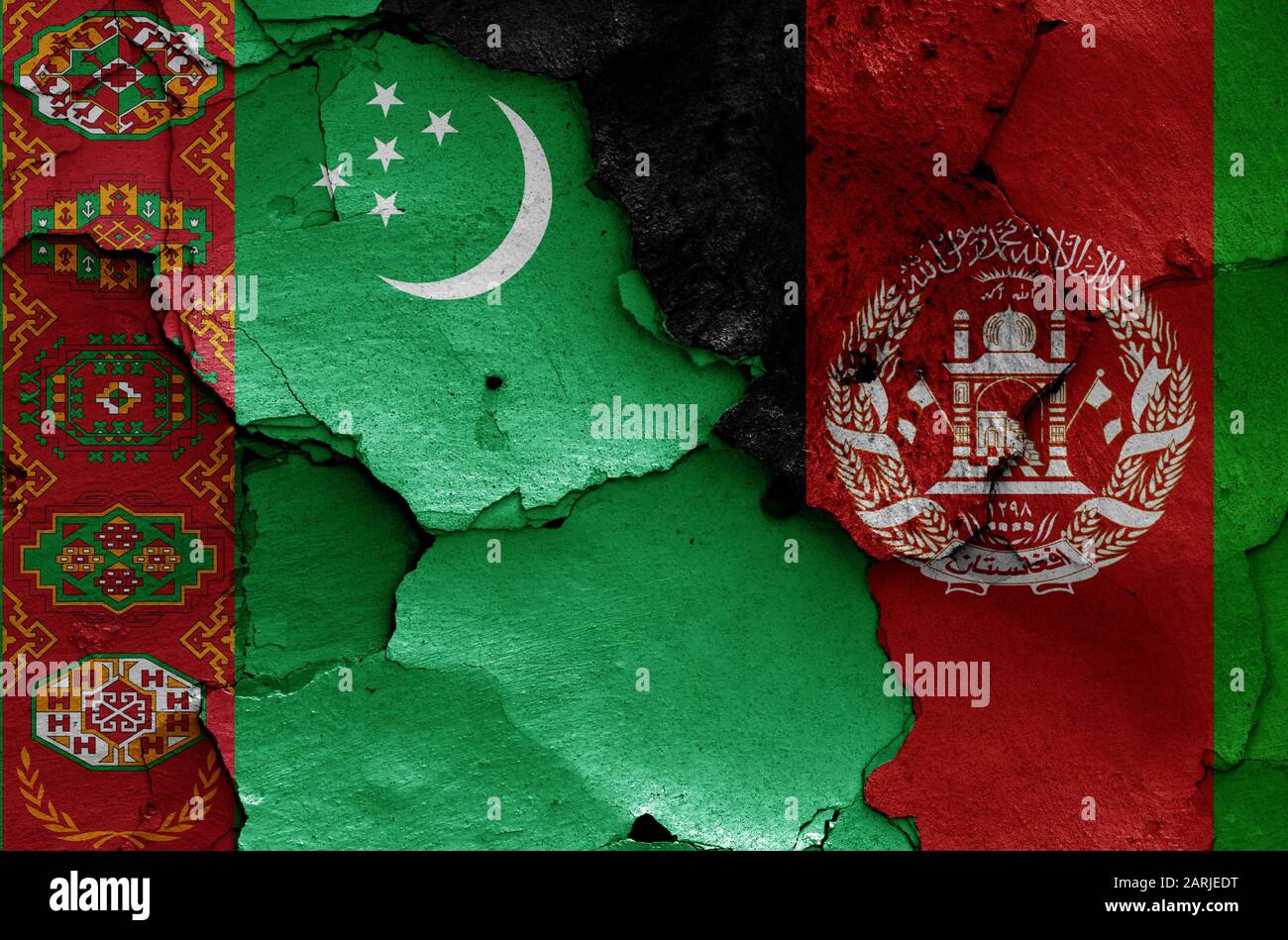 Bandiere del Turkmenistan e dell'Afghanistan dipinte su pareti incrinate Foto Stock