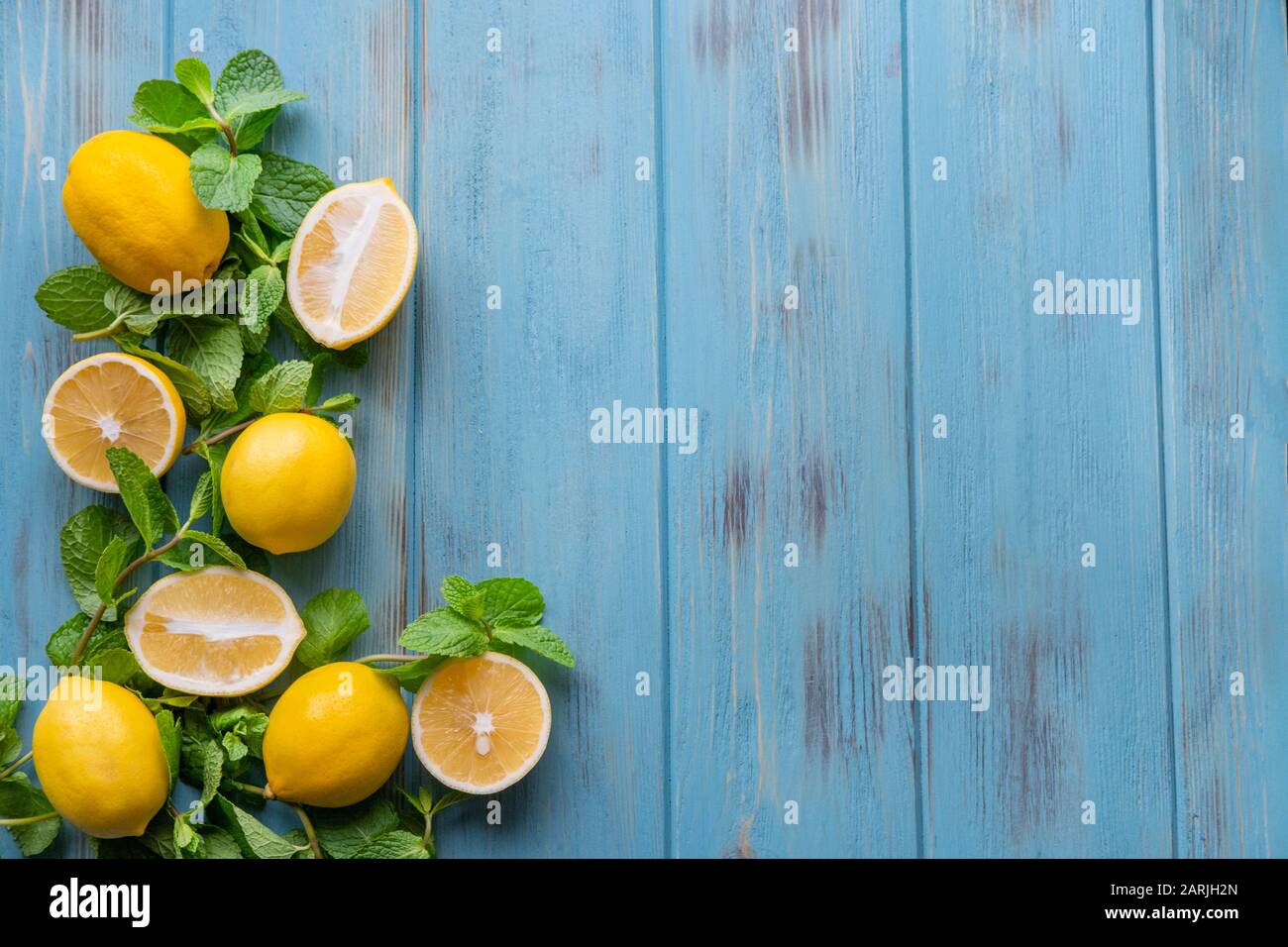 Limoni e menta su sfondo di legno blu. Vitamina C, limonata, estate. Cornice per il post di testo per il blog Foto Stock