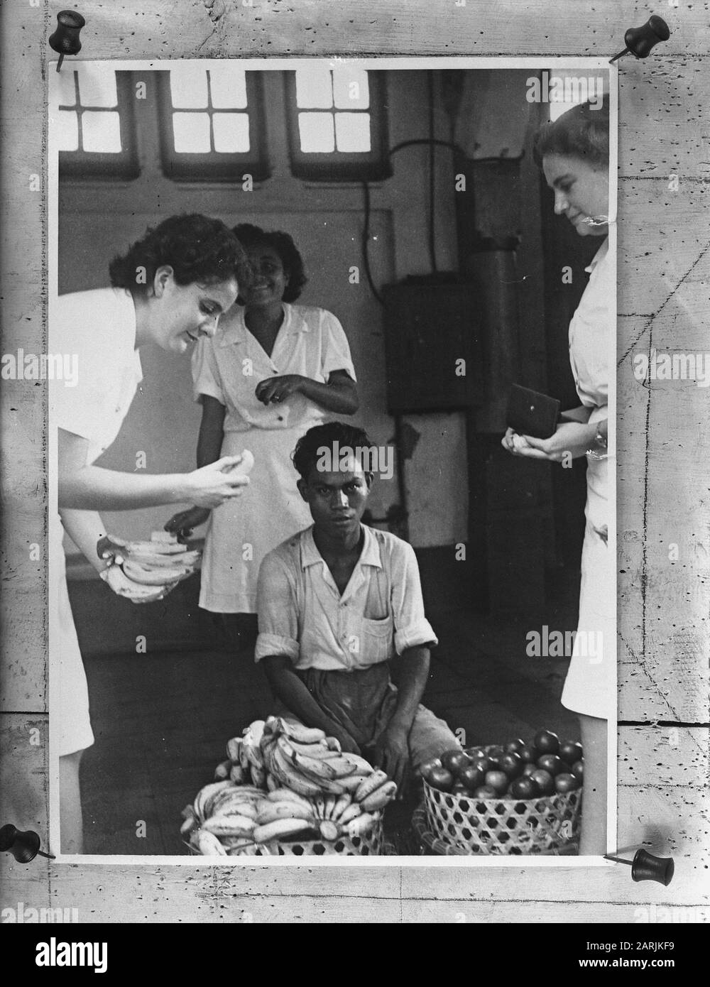Infermieri acquistare frutta da un mercato indonesiano mercante Annotazione: Repronegative Data: 1940-1945 Parole Chiave: Popolazione, marina, seconda guerra mondiale, cibo, donne Foto Stock