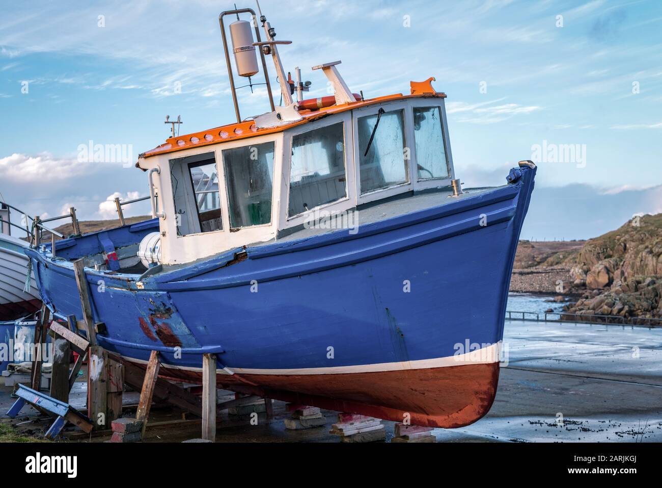 Una vecchia barca irlandese da pesca boscosa fuori dall'acqua sui blocchi al porto Foto Stock