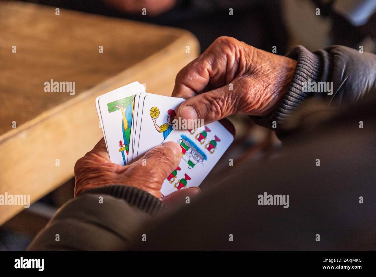 Italia, Sicilia, Provincia Di Palermo, Santa Flavia. 11 Aprile 2019. Uomo che gioca un gioco di carte nel villaggio di pescatori di Santa Flavia. Foto Stock