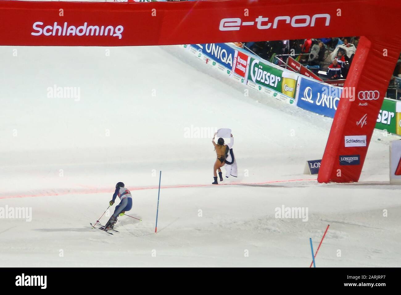 Schladming, Austria. 28th Gen 2020. Una streaker femminile attraversa il traguardo mentre Simon Maurberger d'Italia corre lungo il corso durante la gara di Slalom della Coppa del mondo di Sci Alpino Audi FIS il 28 gennaio 2020 a Schladming, in Austria. Credit: Agenzia Fotografica Sportiva Europea/Alamy Live News Foto Stock