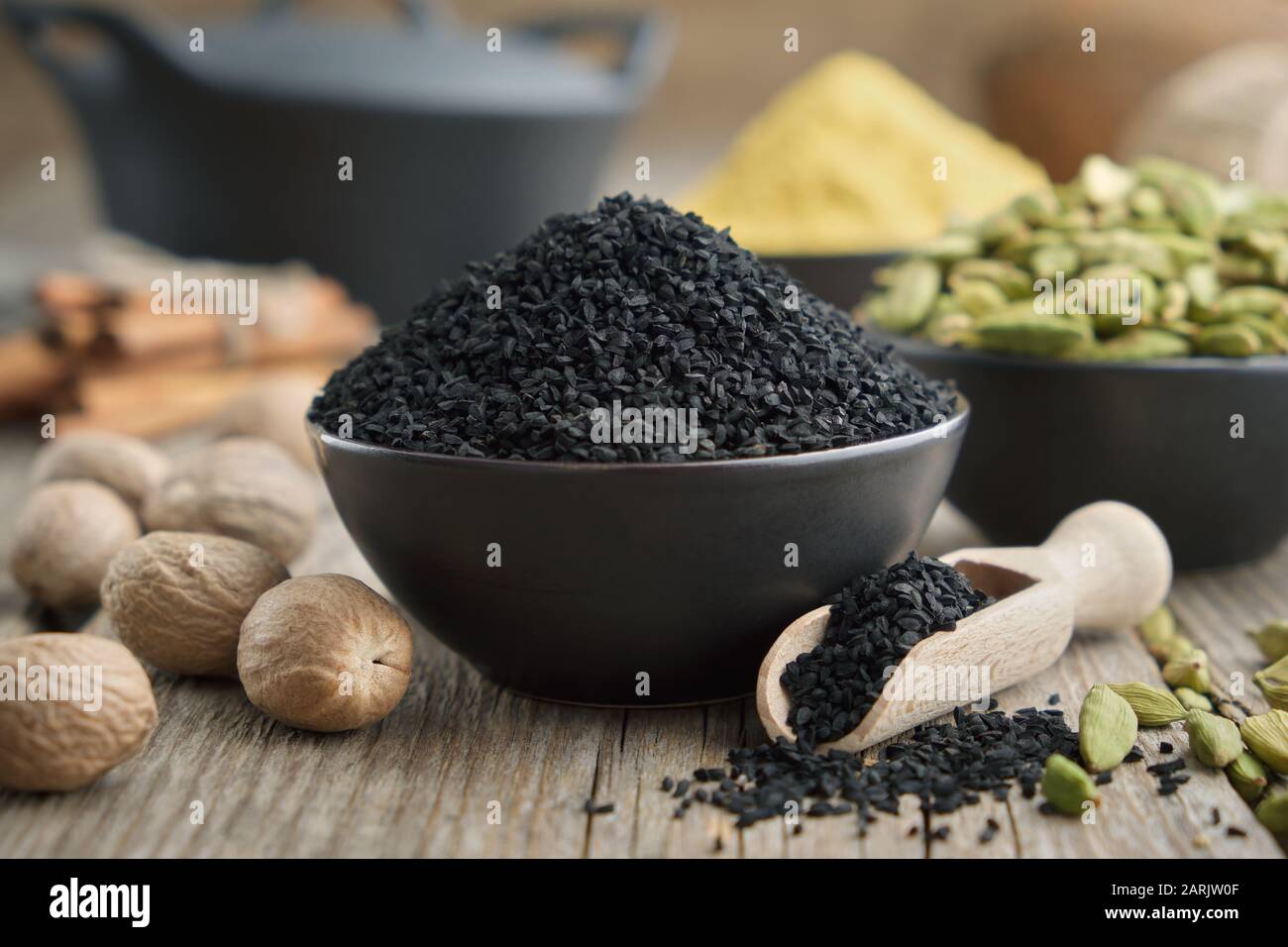 Cumino nero o coriandolo romano semi e spezie aromatiche in tavola: Cardamomo, noce moscata, cannella, curcuma. Ingredienti per cucinare. Trattamento Ayurveda Foto Stock