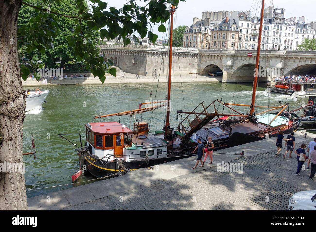 Barca di lavoro legata su Quai de conti con Pont Neuf in background, St Germain-des-Pres, Parigi, Francia Foto Stock