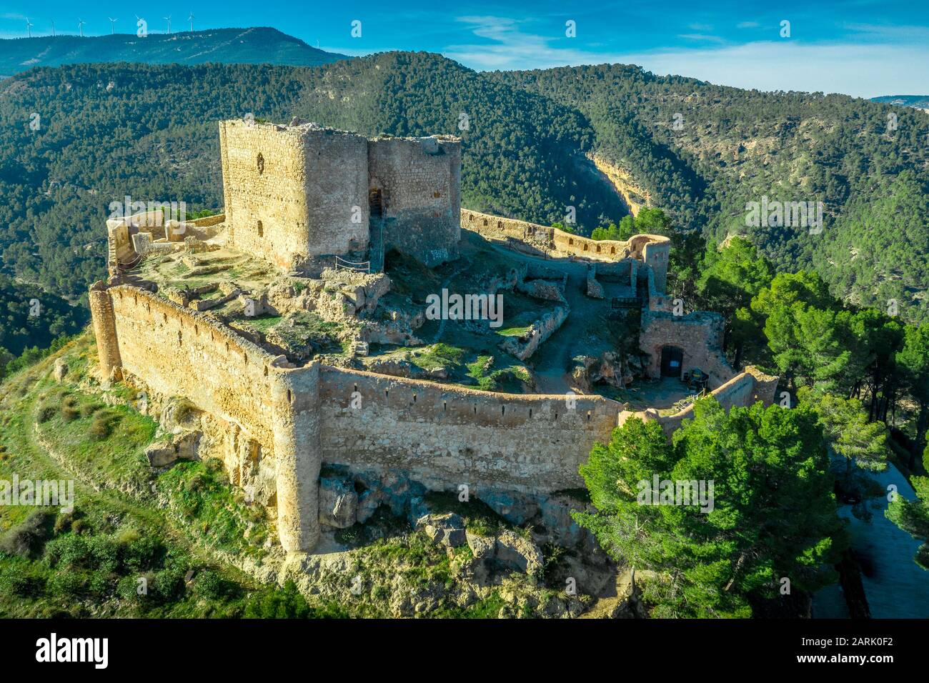 Veduta aerea del castello di Jalance in Spagna su una collina del 12th secolo costituito da cortile interno del castello, forma irregolare parete esterna con torre rotonda Foto Stock