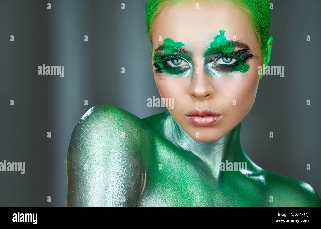 Alta Moda modello. Una straordinaria donna con Verde metalizzato trucco e perde neon verde vernice. Glitter vivid trucco Foto Stock