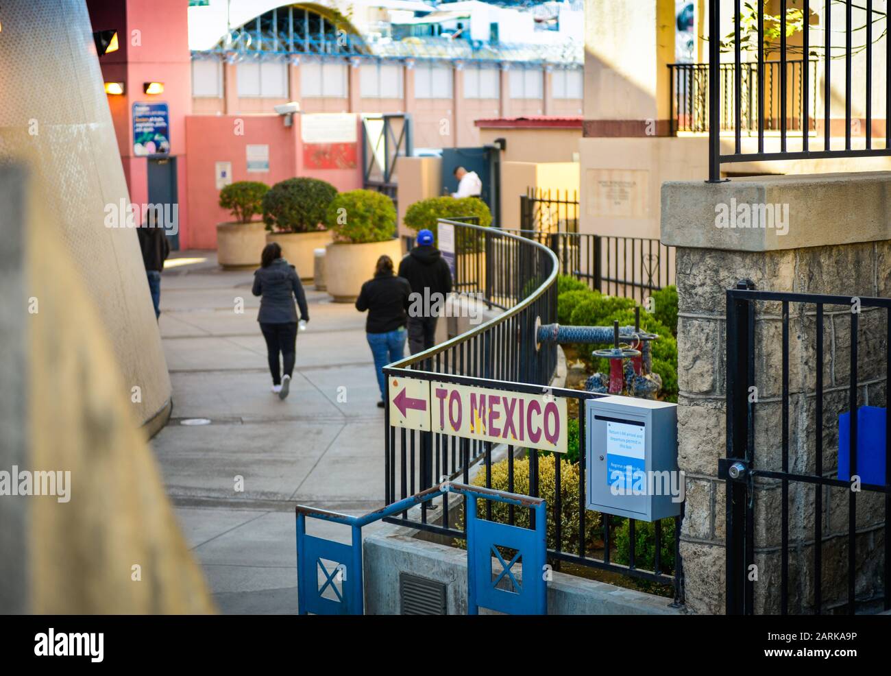 Un cartello che indica il Messico, con vista posteriore delle persone che camminano verso il confine USA-Messico in un punto di check-in a Nogales, AZ, USA Foto Stock
