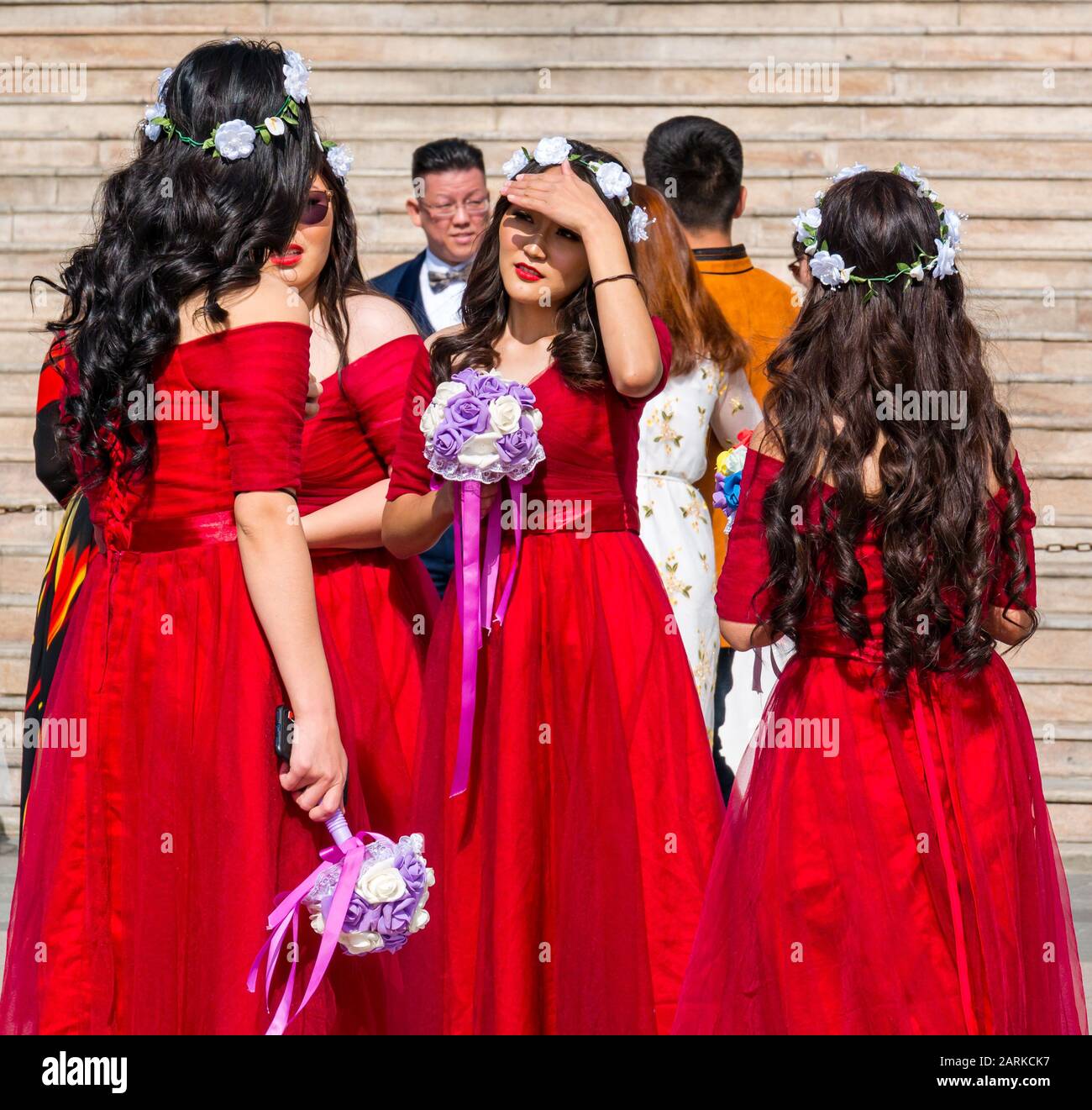Bridesmaids in abiti rossi corrispondenti a festa di nozze, Sükhbaatar Square, Ulaanbaatar, Mongolia Foto Stock