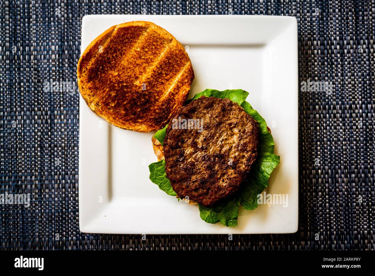 Un hamberger semplice su un piatto bianco Foto Stock