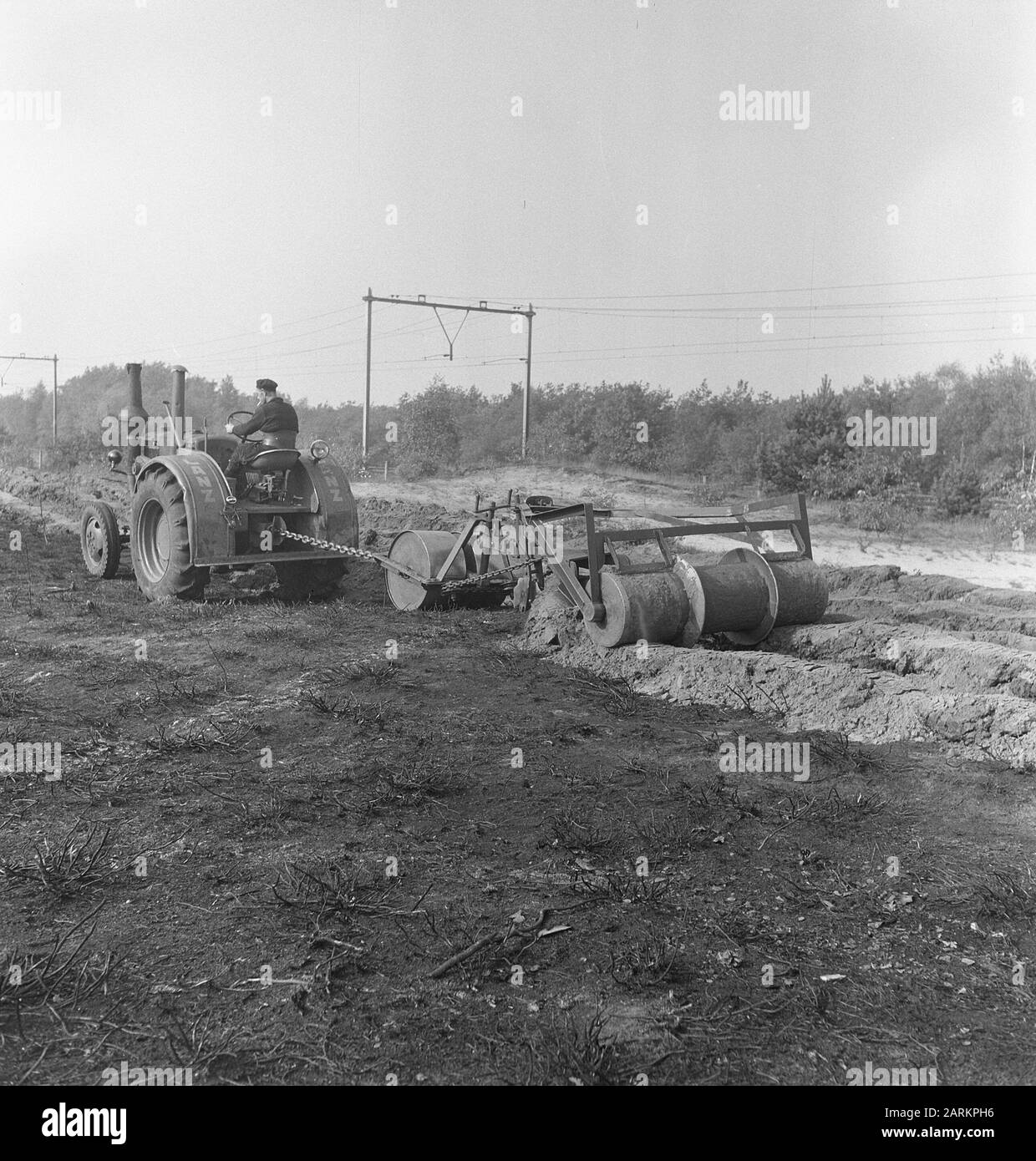 Coltivazione. Disegna slot con trattore e attrezzo agricolo Annotazione: Vicino a una ferrovia Data: Parole Chiave non utilizzate: Lavoratori, lavorazione del terreno, macchinari agricoli, attrezzi Foto Stock