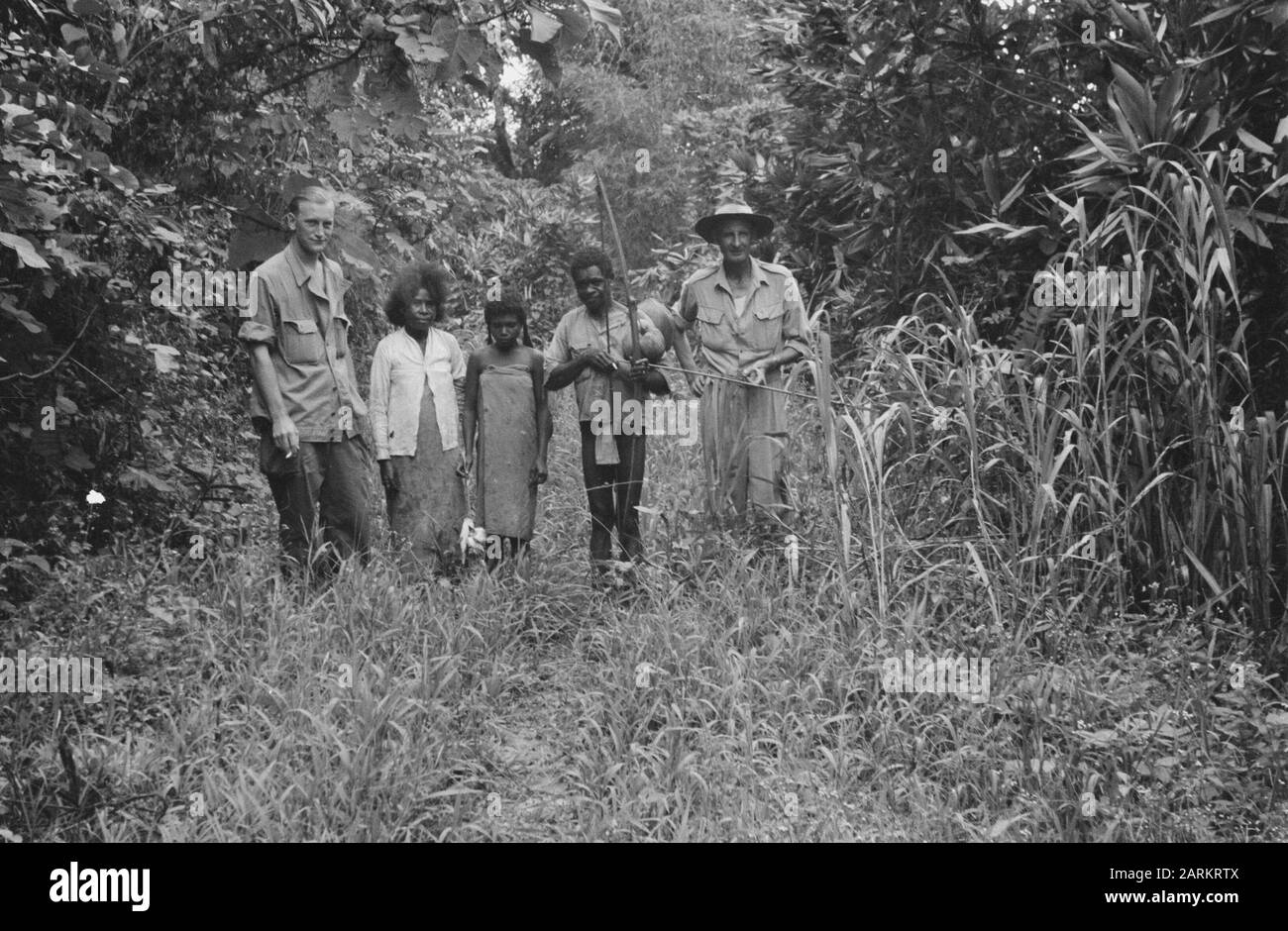 Grande Oriente [reporter? Left Poses with Papua family and man in Australian Hat] Data: 10 novembre 1947 luogo: Indonesia, Dutch East Indies Foto Stock