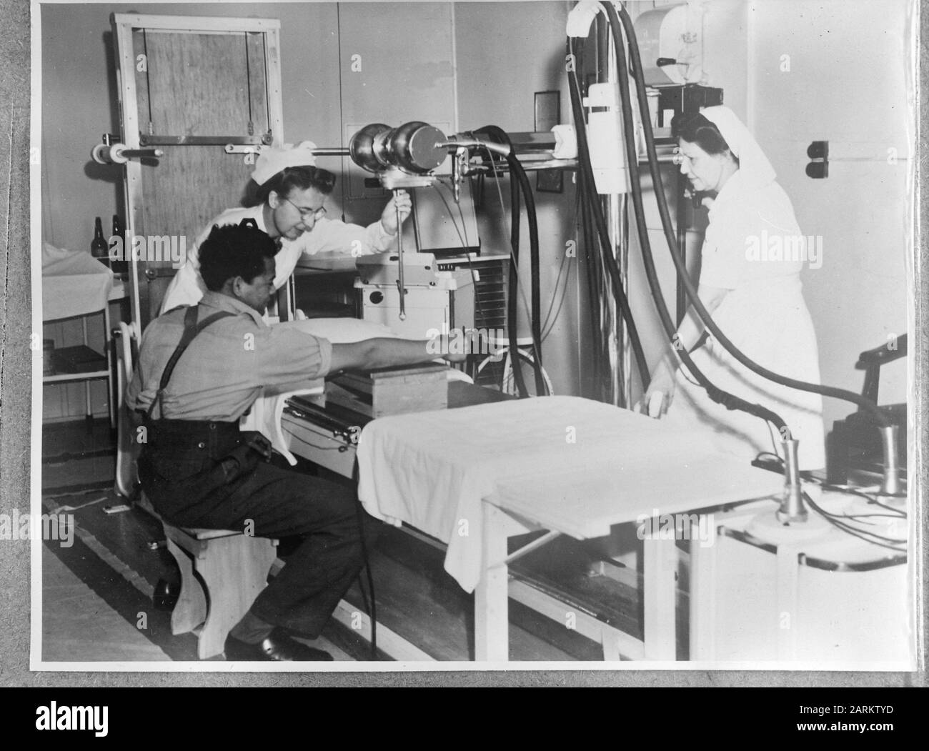 La nave dell'ospedale Orange Hospital Arancio lascia Melbourne per una missione di salvataggio a Batavia. Una fotografia a raggi X del braccio del sergente Sudarto (KNIL) è presa dagli infermieri Van der Roest (a sinistra) e M. van der Berg Data: 22 ottobre 1945 luogo: Australia Parole Chiave: Spedizione Nome personale: Berg, M. van der Foto Stock
