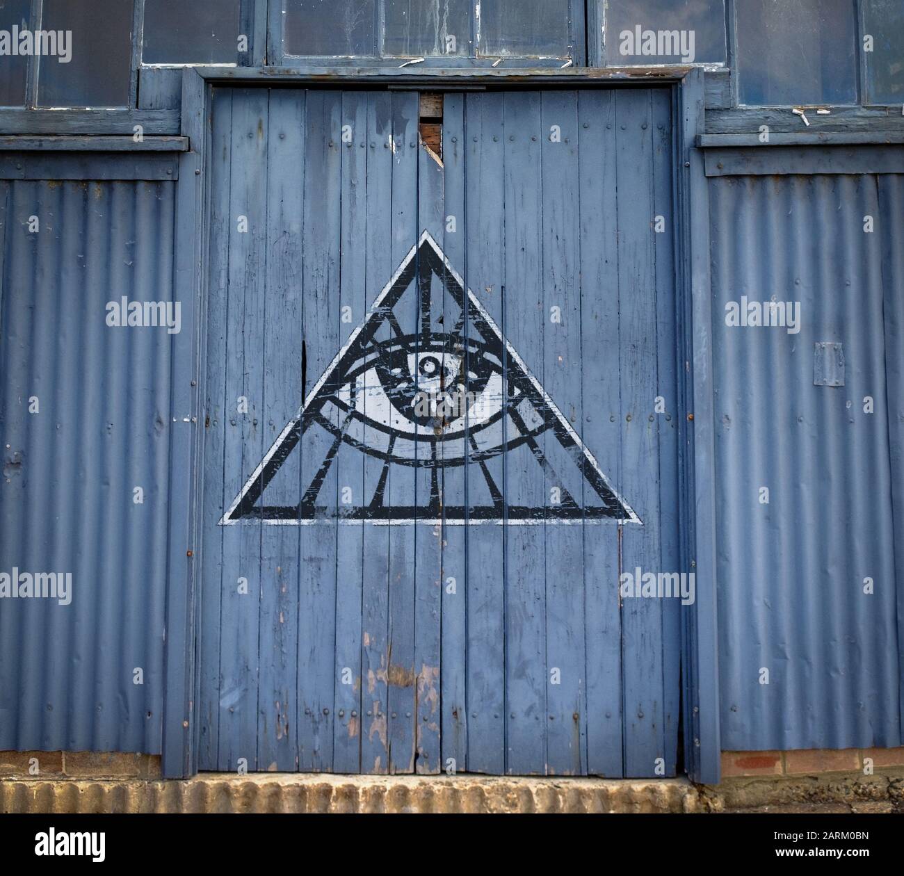 Tutti vedendo graffiti occhio su vecchio magazzino porta, teoria cospirazione segreto concetto di società Foto Stock