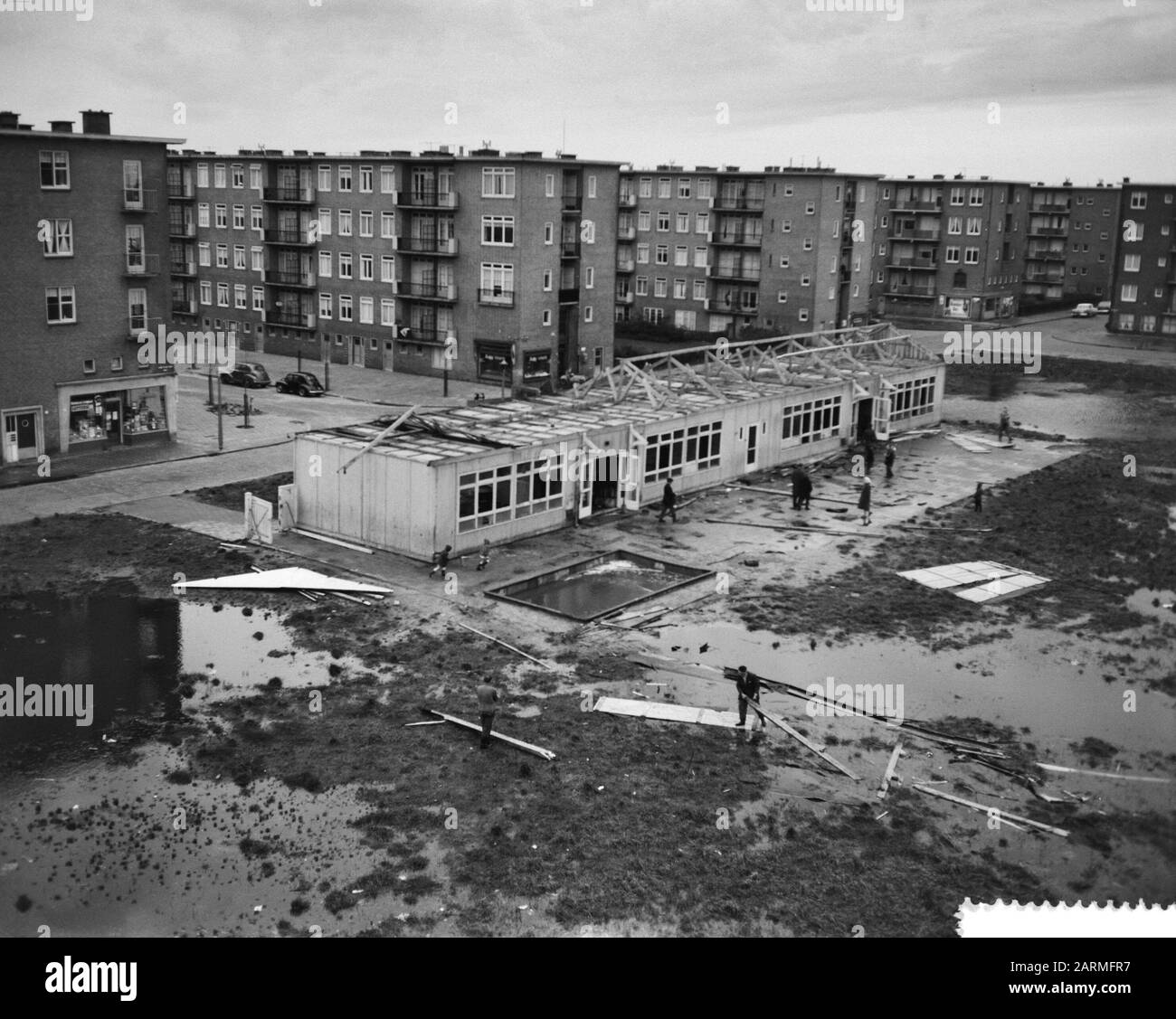Danni da tempesta ad Amsterdam, tetto saltato lontano dalla scuola di emergenza Data: 4 Dicembre 1960 luogo: Amsterdam, Noord-Holland Parole Chiave: Tetti, scuole di emergenza, stormschades Foto Stock