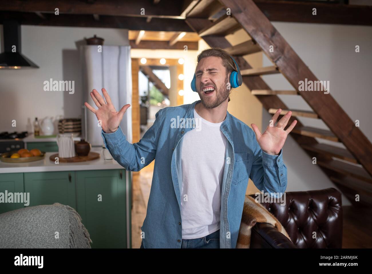 L'uomo cantava la sua canzone preferita mentre indossava gli auricolari Foto Stock