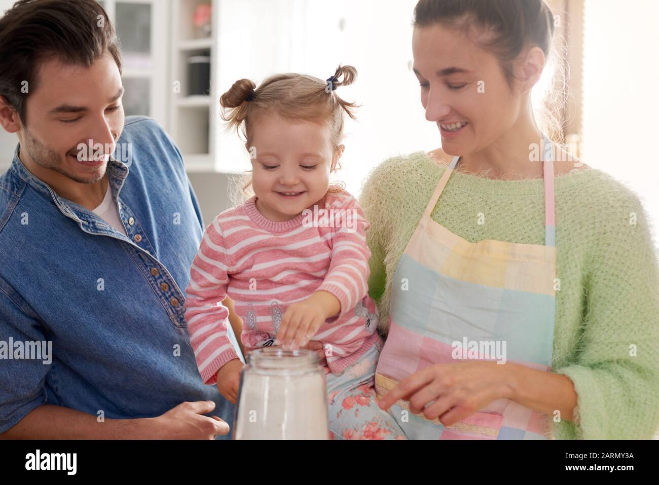 I genitori e la loro figlia che fanno da forno insieme Foto Stock