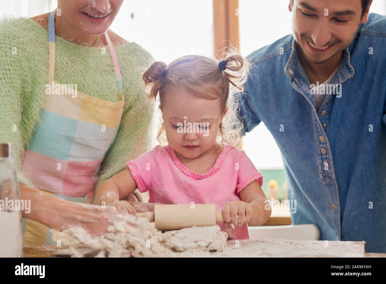 Cottura del bambino sotto l'occhio vigile dei genitori Foto Stock