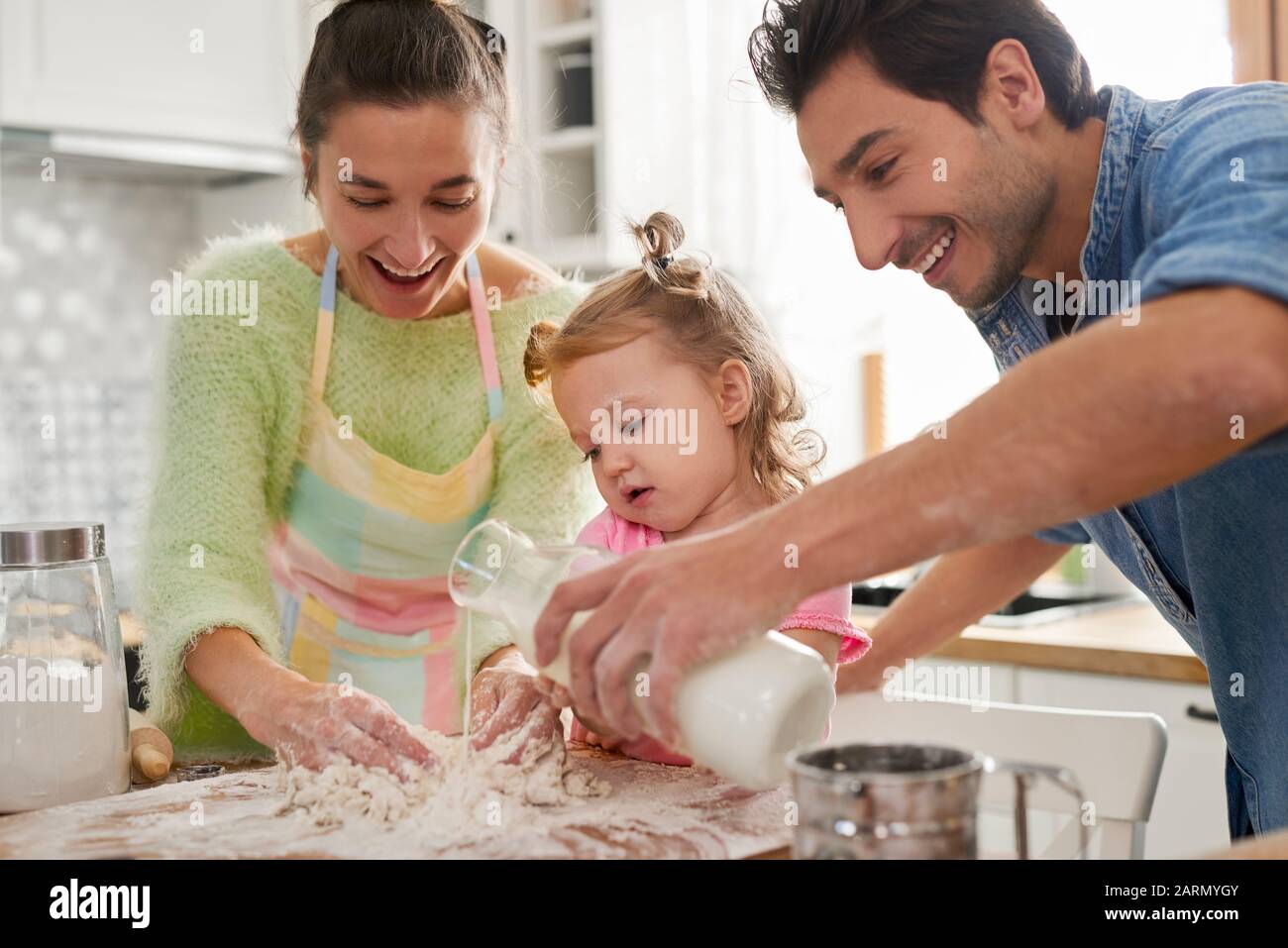 Figlia che aiuta i genitori con la cucina Foto Stock
