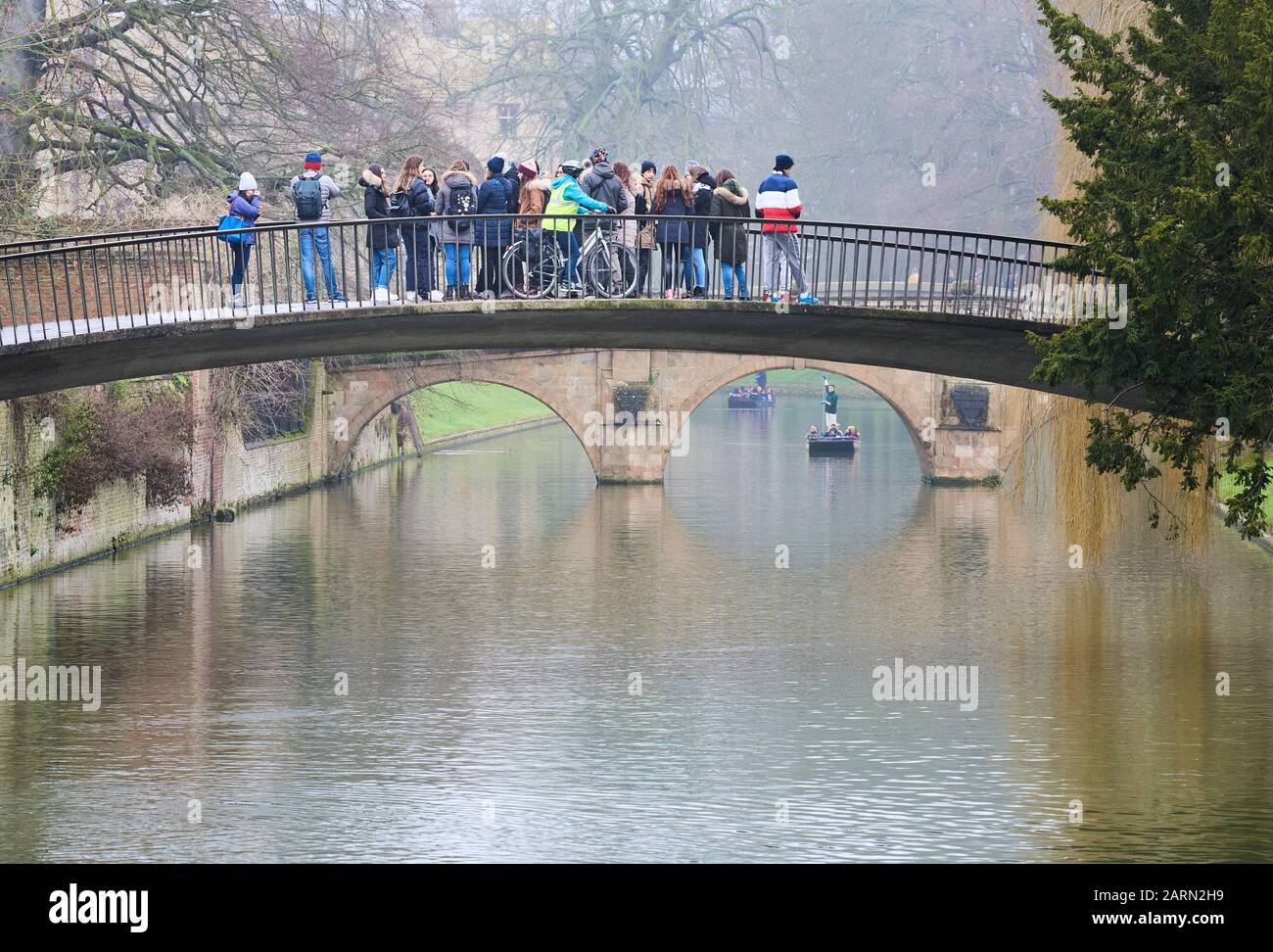Un gruppo di giovani turisti si trovano sul ponte di corsia Garret Hostel sul fiume Cam dal Trinity Hall College, università di Cambridge, Inghilterra, su una nebulosa Foto Stock