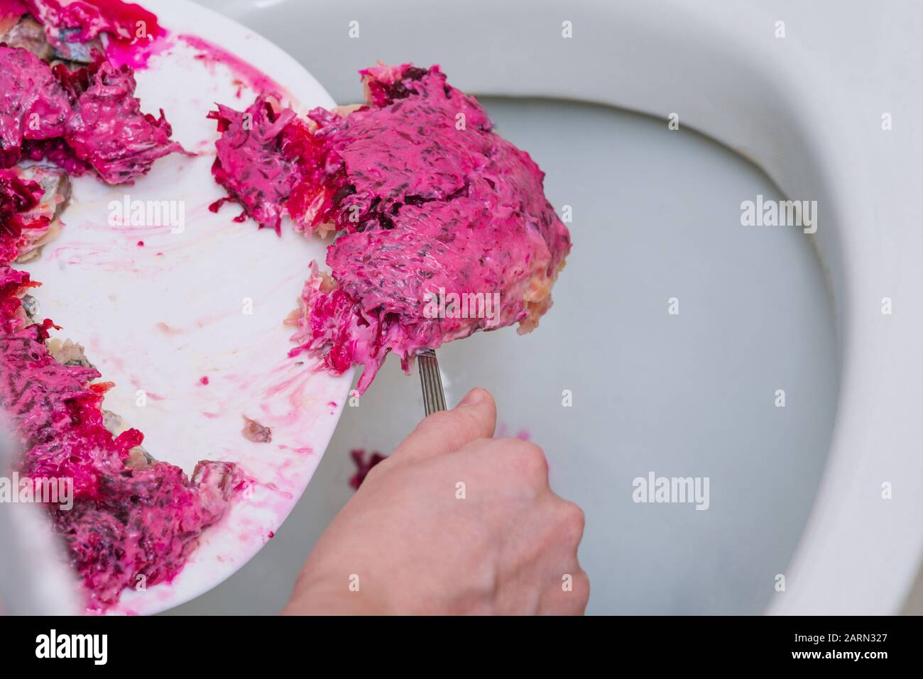 I prodotti pericolosi marcio vengono gettati nella toilette. Barbabietole e insalata di pesce con maionese. Pulizia dopo una festa o una vacanza. Foto Stock