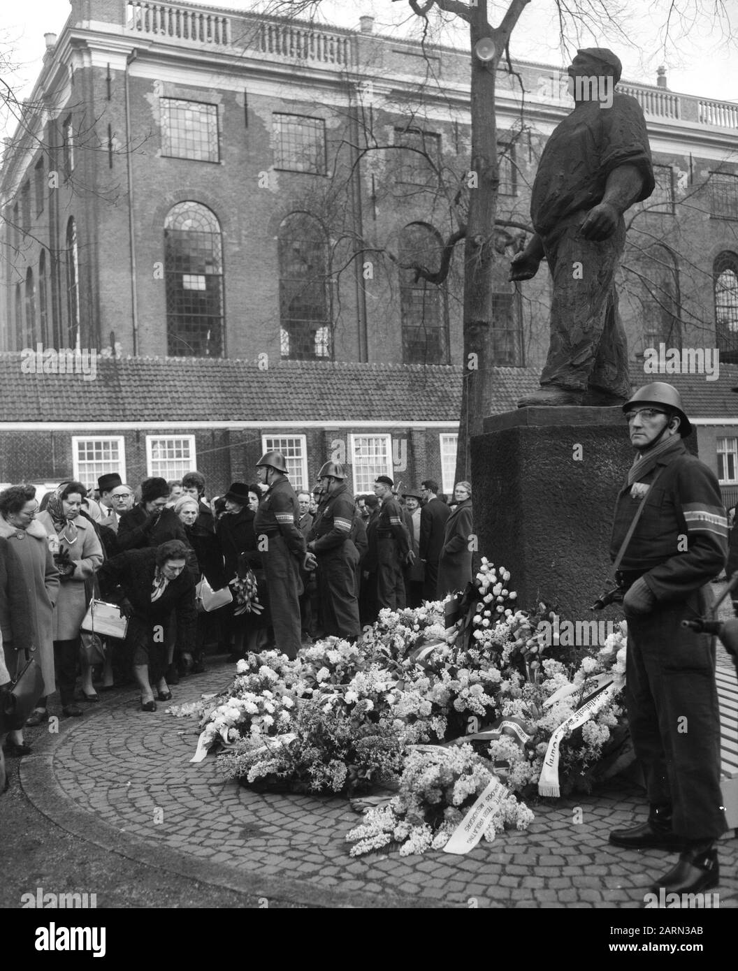 Commemorazione febbraio sciopero 1941 a Jonas Daniel Meijerplein. Dopo il giuramento che posò la gente defilò oltre il monumento De Dokwerker Annotazione: De Dokwerker è un disegno di Mari Andriessen Datate: 25 febbraio 1964 Parole Chiave: Defilés, commemorazioni, monumenti di guerra Foto Stock