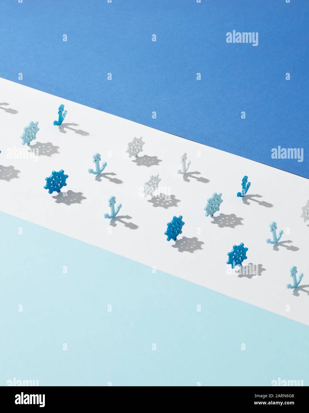 Ampia corsia bianca con giocattoli in plastica di ruote marine e ancoraggi ombre su sfondo azzurro, copia spazio. Foto Stock