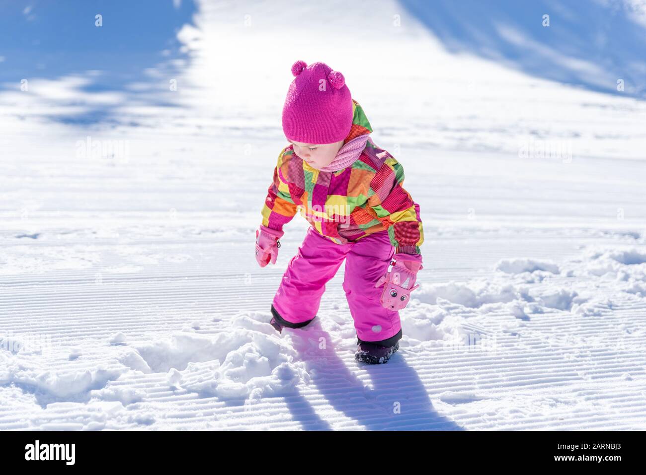 Bambina sta giocando nella neve. Le ragazze indossano un cappello rosa,  sciarpa, giacca, guanti e un abito. Concetto di vacanza invernale Foto  stock - Alamy