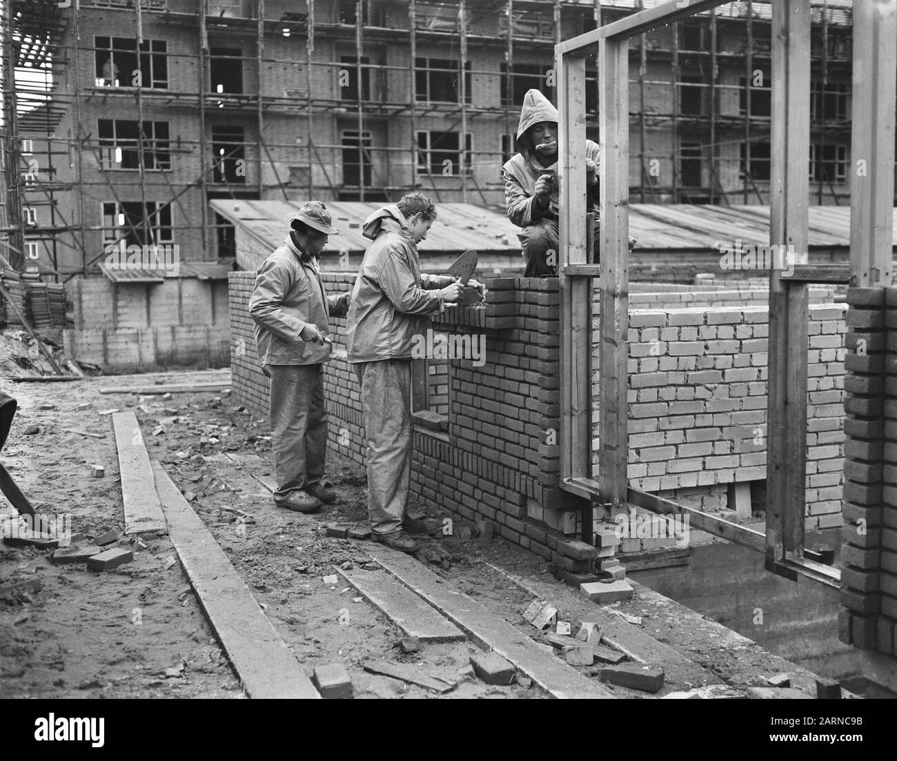 Accelerazione edilizia abitativa in inverno (Rijswijk), abbigliamento governativo per gli operai edili Data: 19 dicembre 1955 Località: Rijswijk, Zuid-Holland Parole Chiave: Operai edili, KLOTHE, GOVERNO, INVERNO, ALLOGGIO Foto Stock