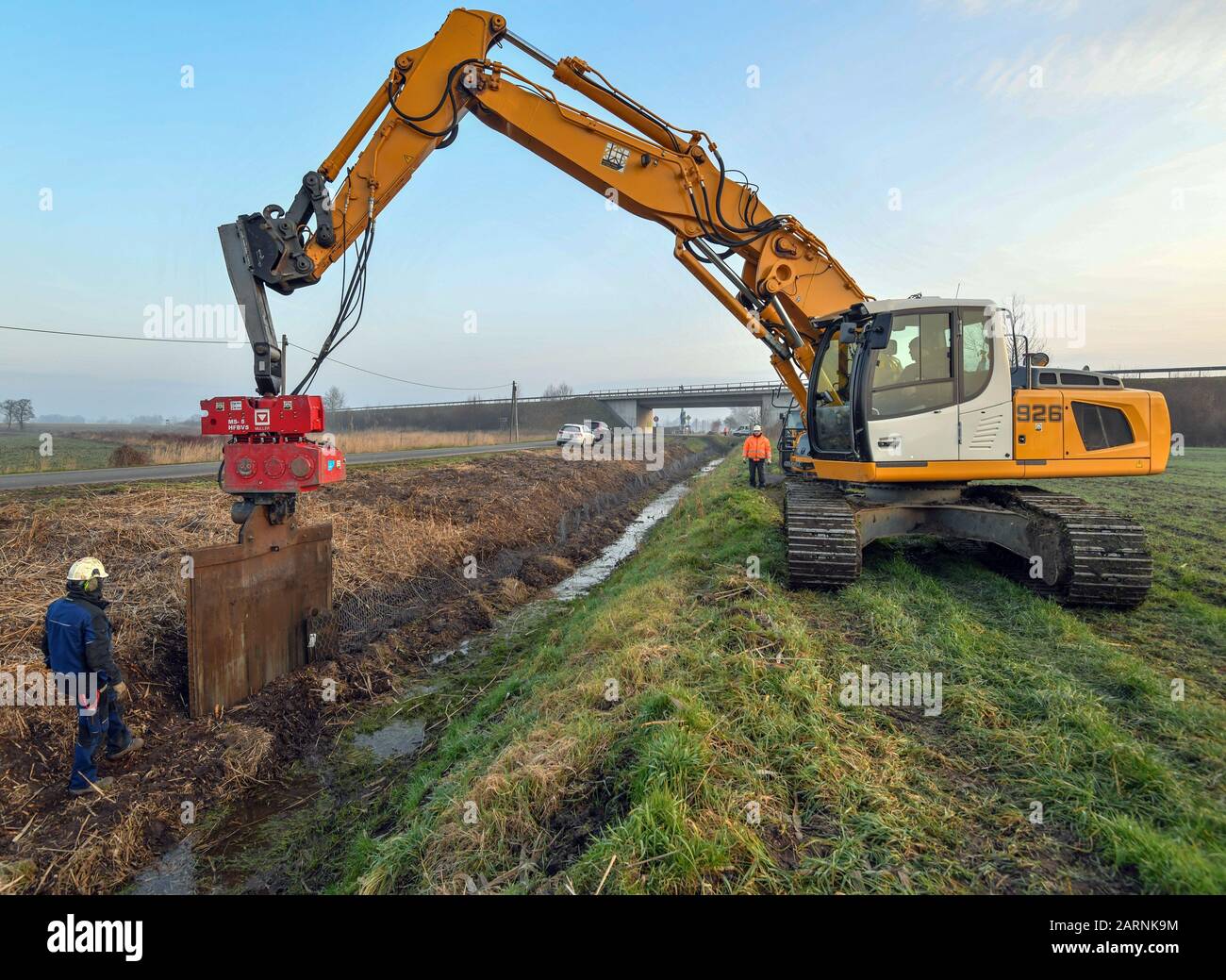 27 gennaio 2020, Brandenburg, Groß Neuendorf: I dipendenti di Ingenieur Wasser und Tiefbau GmbH (IWT) Frankfurt (Oder) stanno portando a terra una griglia speciale per la difesa del castoro su un lato di un fossato nell'Oderbruch. Il brevetto della società di Francoforte rallenta i castori dell'Oderbruch. A fossati e dighe, tappeti protettivi sepolti verticalmente impediscono agli animali notturni di scavare nel terreno. Tuttavia, il castoro si sente a casa nel paesaggio culturale. Foto: Patrick Pleul/dpa-Zentralbild/ZB Foto Stock