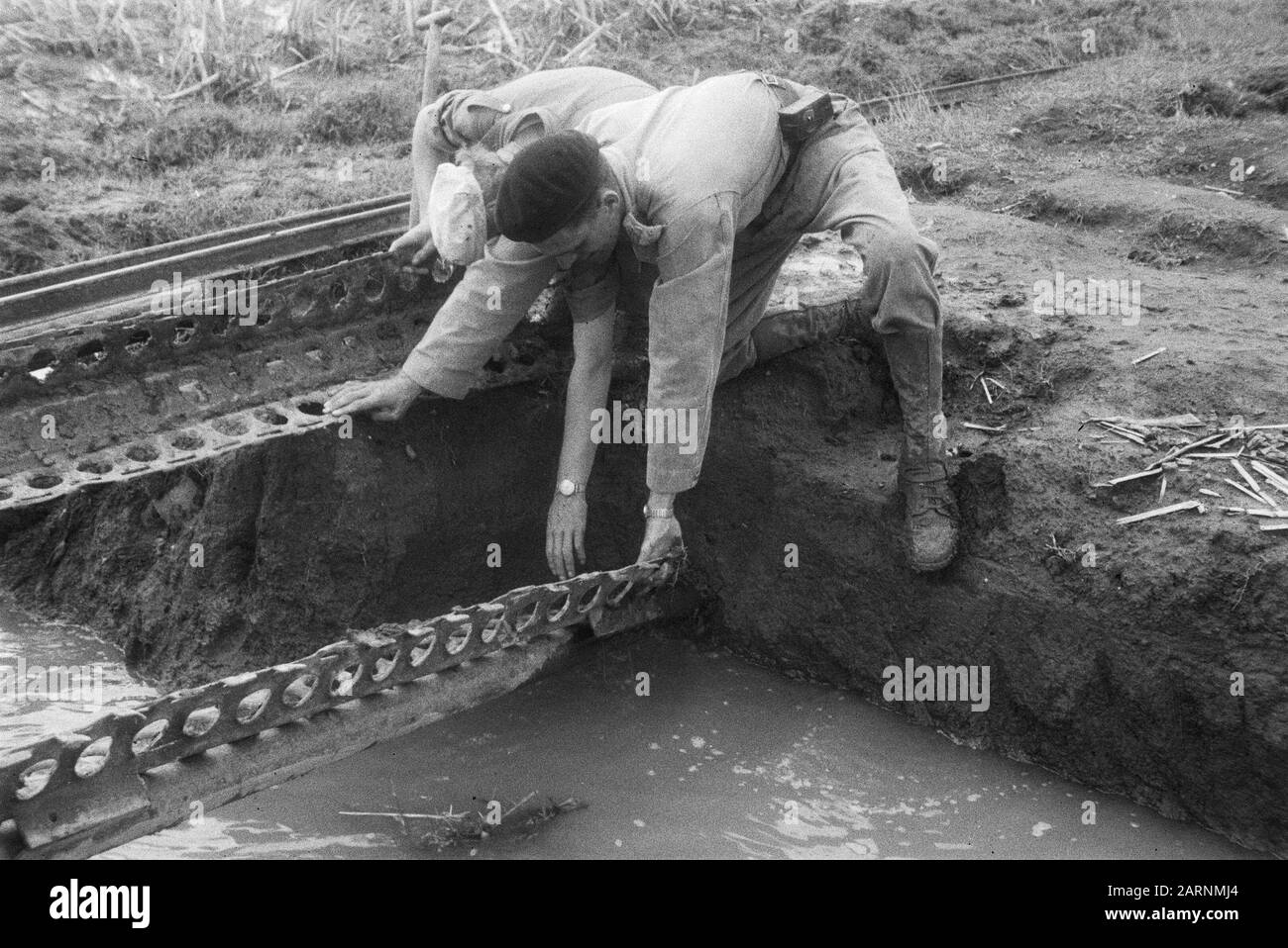 Jeep e vagoni corazzati in azione a sud-est di solo Due uomini stanno cercando di riparare provvisoriamente un ponte ferroviario con lamiere di acciaio perforate Data: 28 marzo 1949 luogo: Indonesia, Java, Indie orientali olandesi, solo Foto Stock